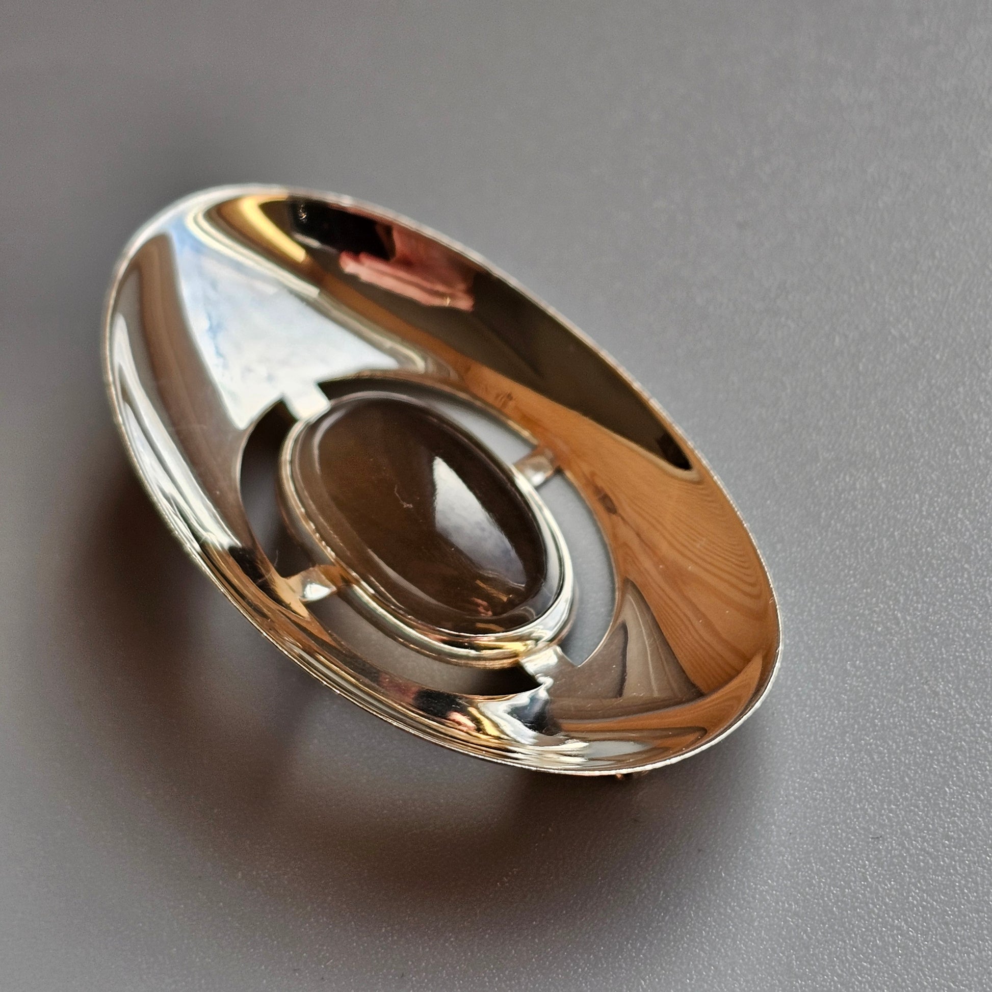 Shiny metallic disc or ring with a circular opening in the center.