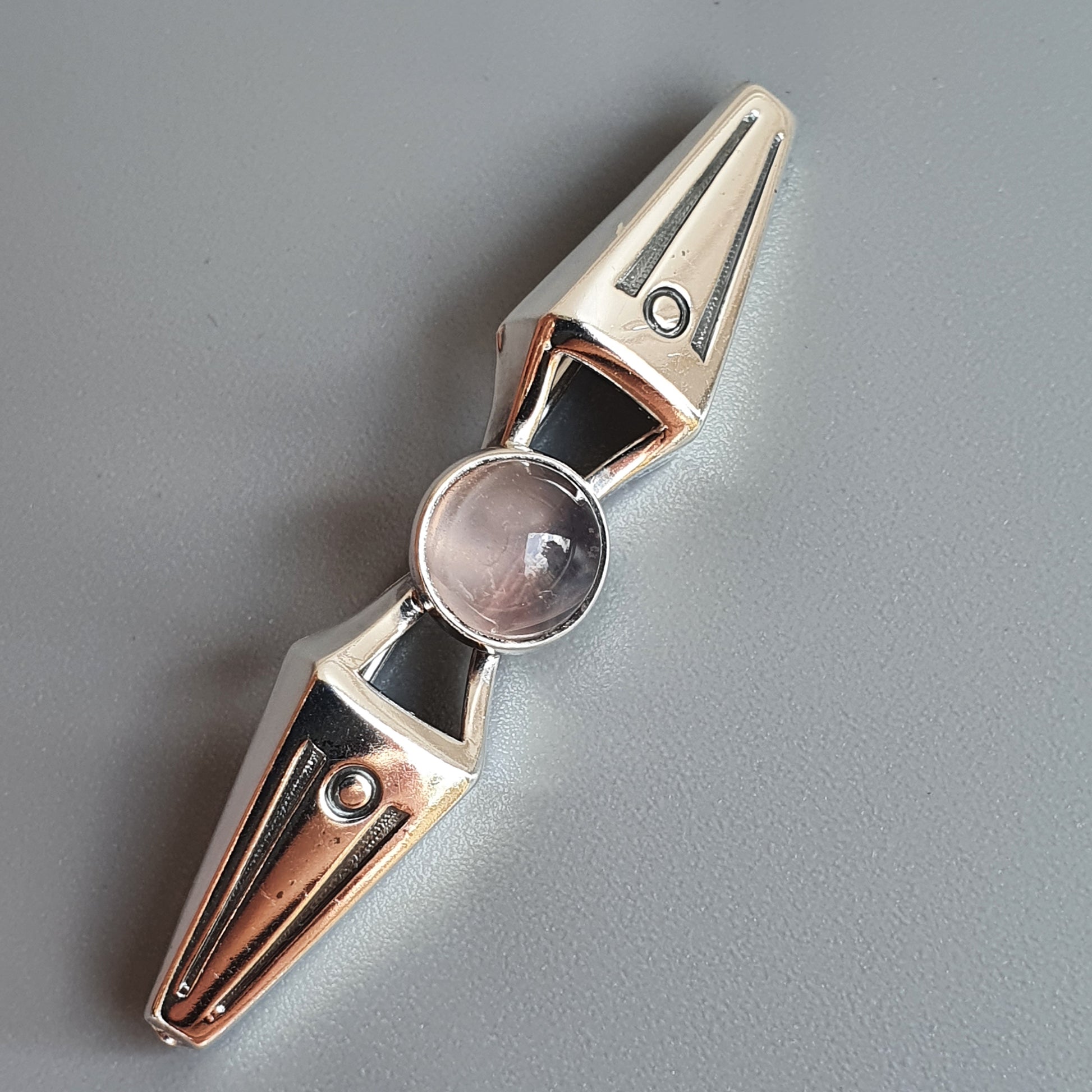 Metallic fidget spinner with a central glass or crystal-like element.