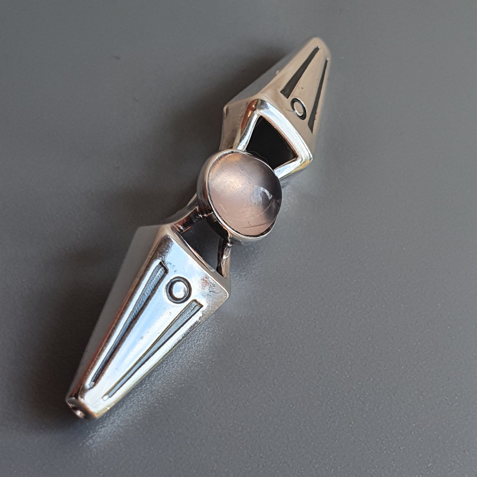 Metallic fidget spinner with pointed ends and a central circular bearing.