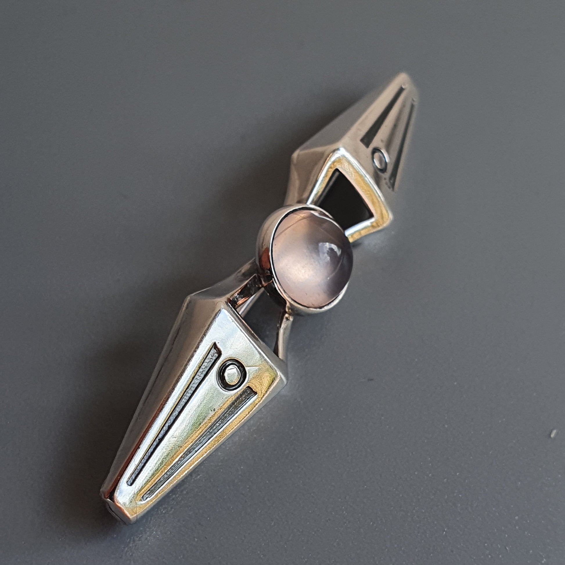 Metallic fidget spinner with triangular arms and a central circular bearing.