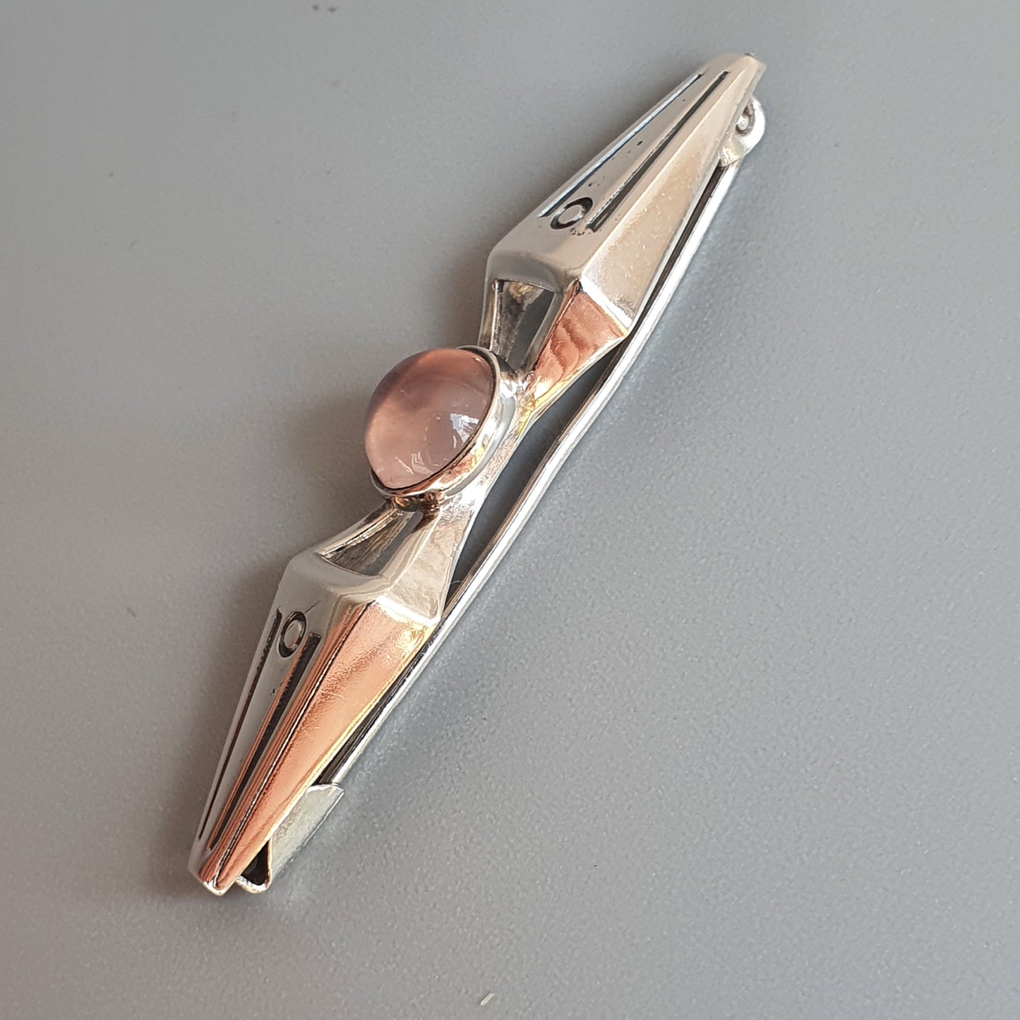 Metal hair clip with a rose gold or copper-colored accent.