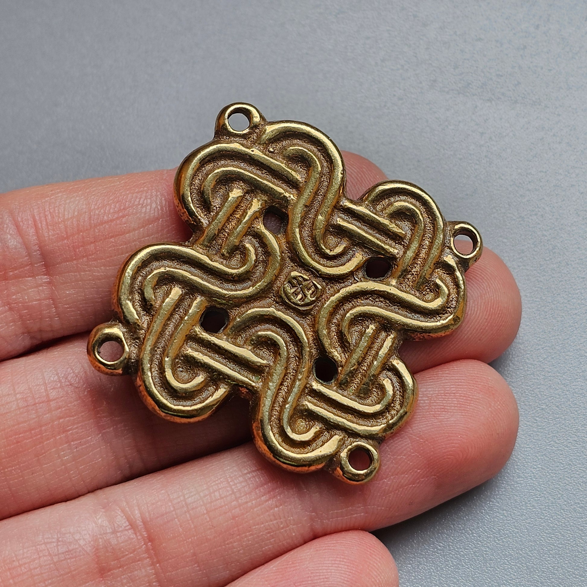 Celtic knot pendant with interlaced loops forming a symmetrical design.