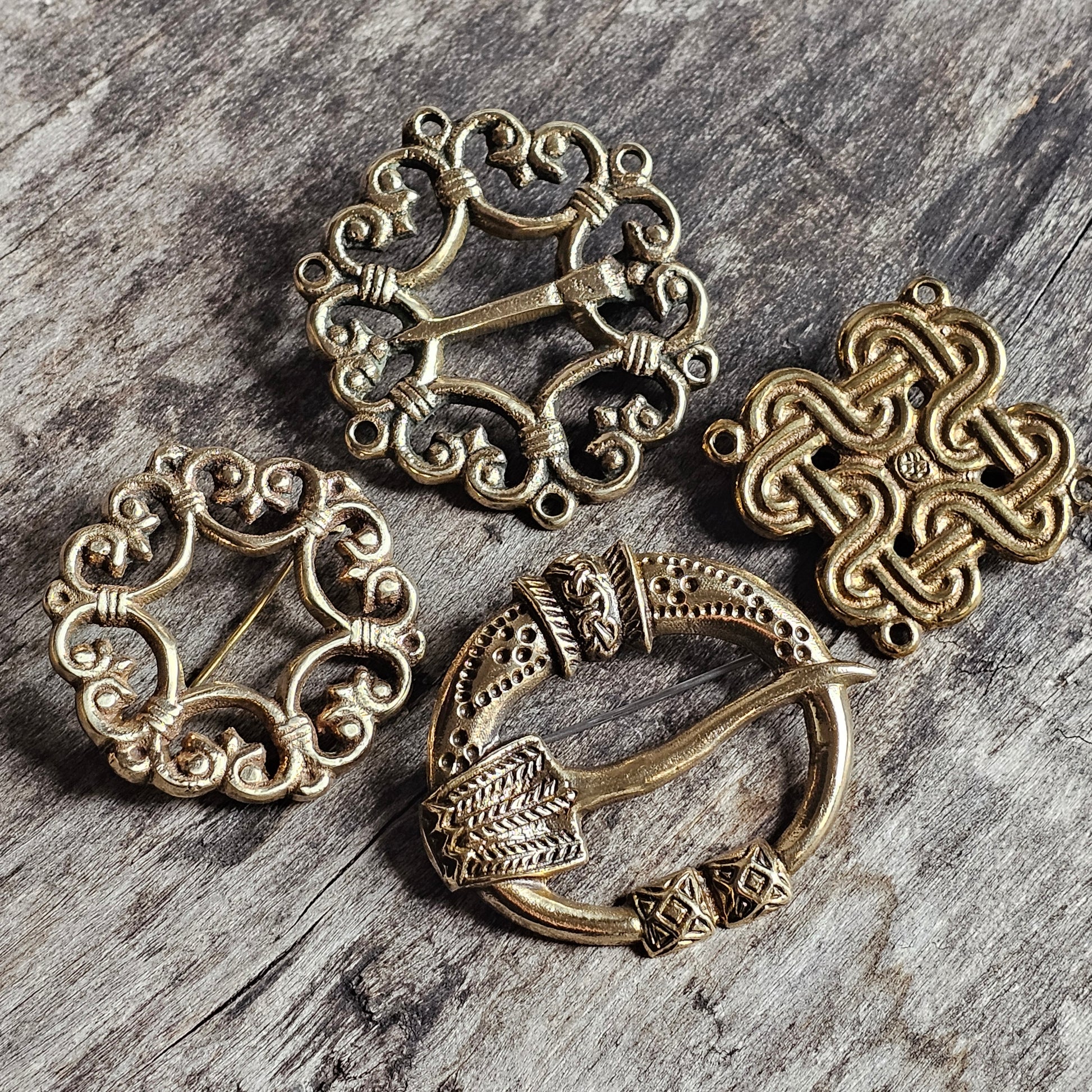 Collection of antique-style metal brooches or pendants with intricate Celtic-inspired designs.