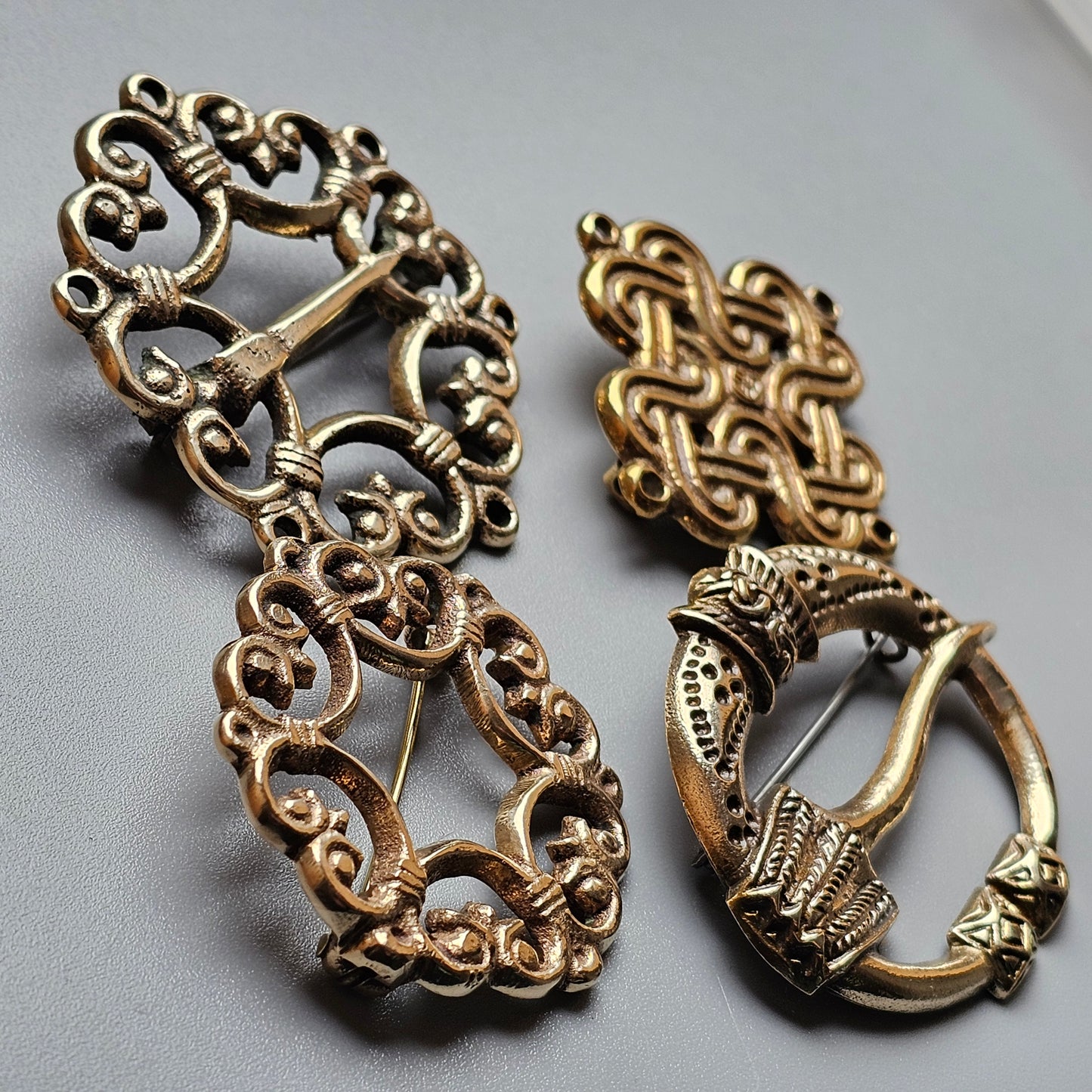 Ornate metal brooch or pin with intricate filigree designs.