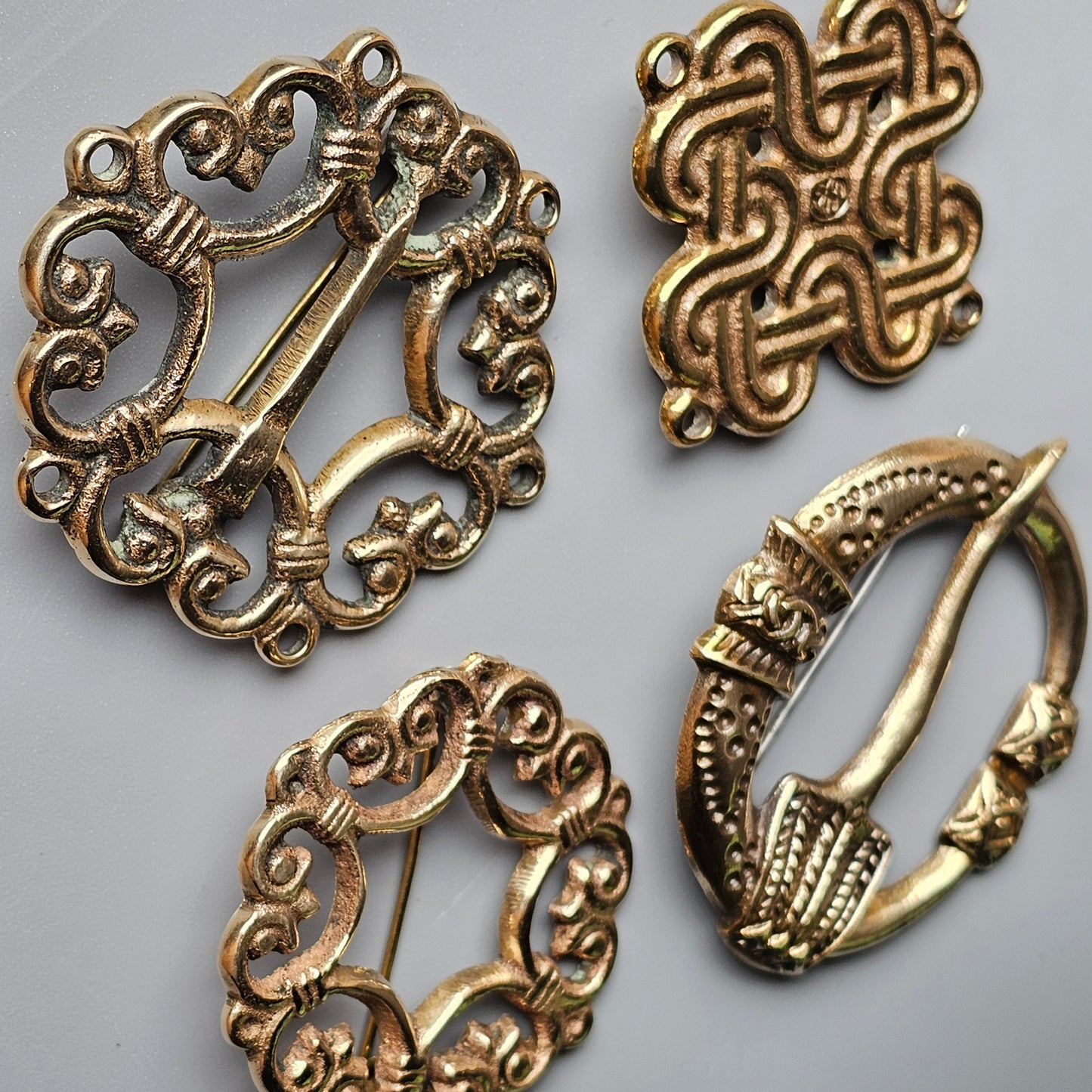 Collection of ornate antique metal brooches and clasps with intricate designs.