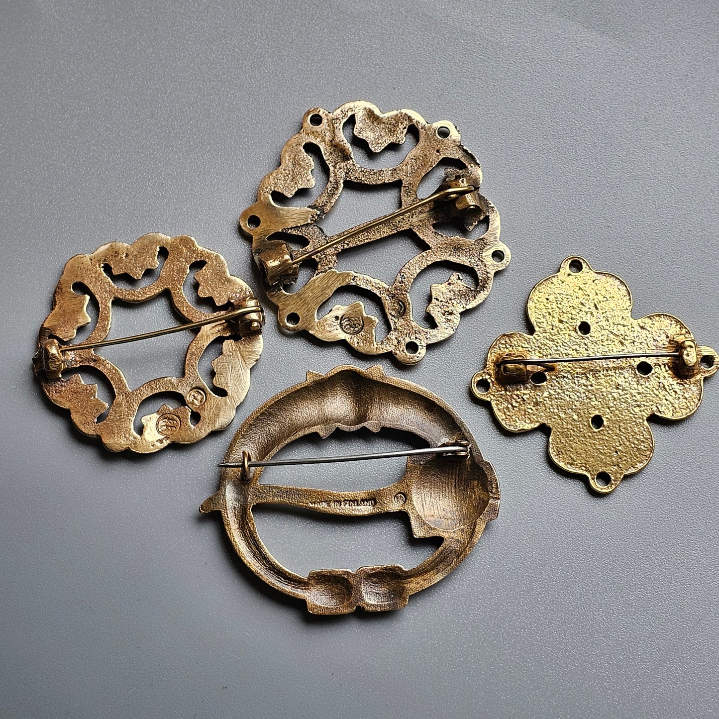 Collection of antique metal brooches or clasps with ornate designs.