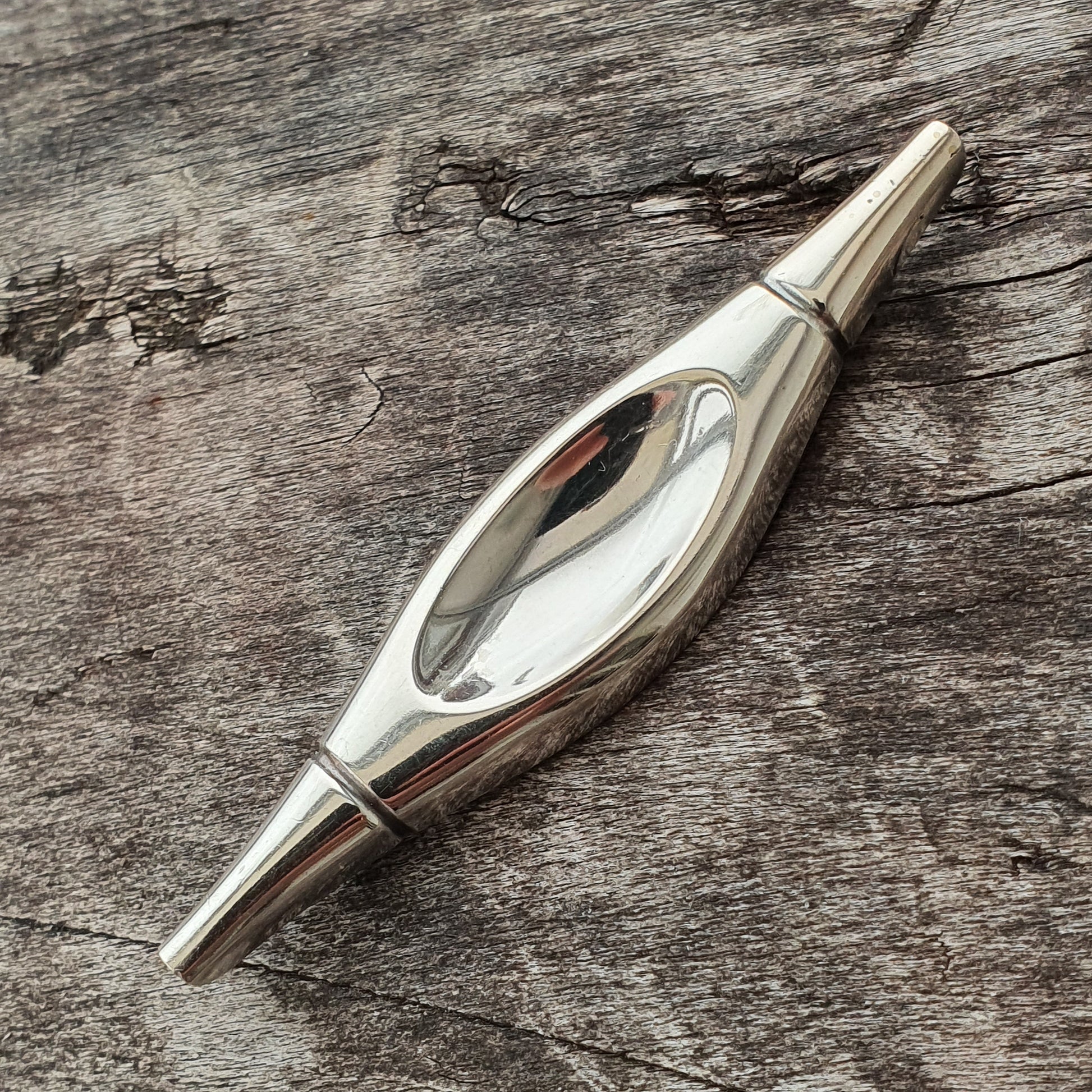 Sleek, silver-colored metal spinning top with a reflective surface.