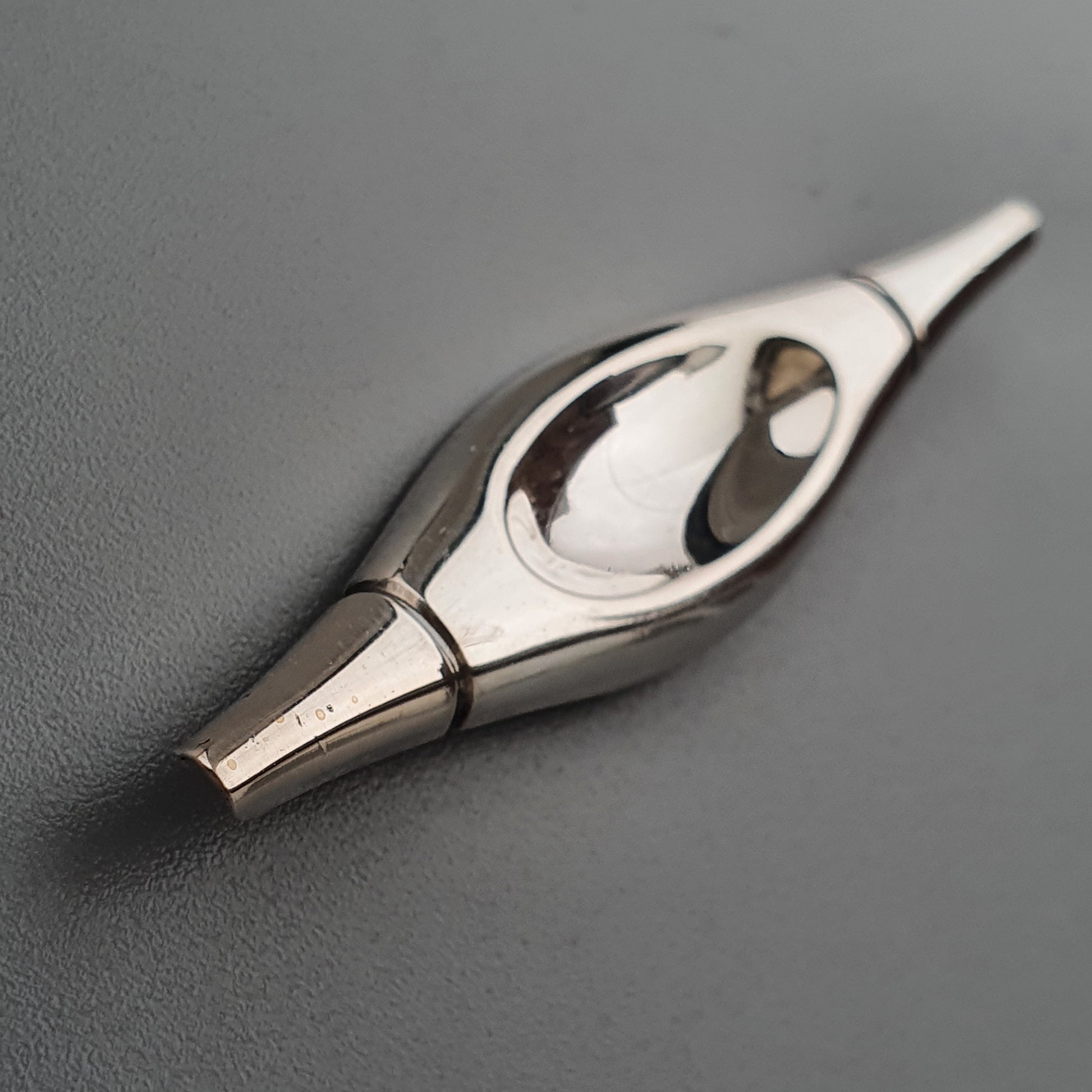 Metallic fountain pen nib with a sleek, elongated design.