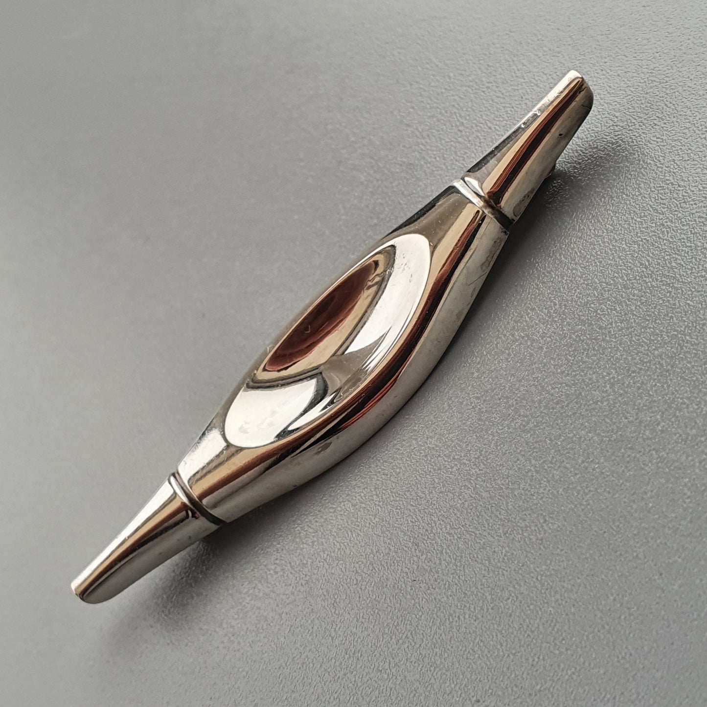 Sleek metallic spinning top with curved, organic design elements.