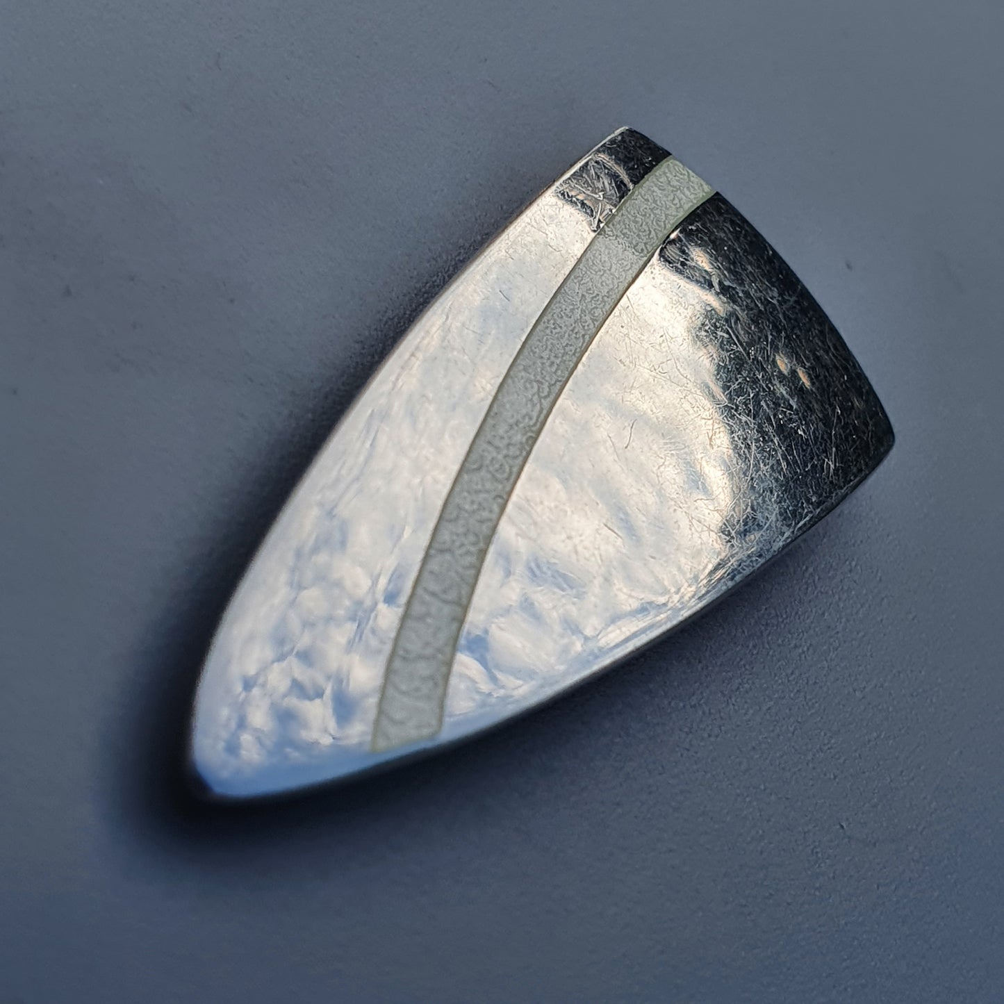 Triangular metallic white enamel brooch with hammered texture by Platinoro