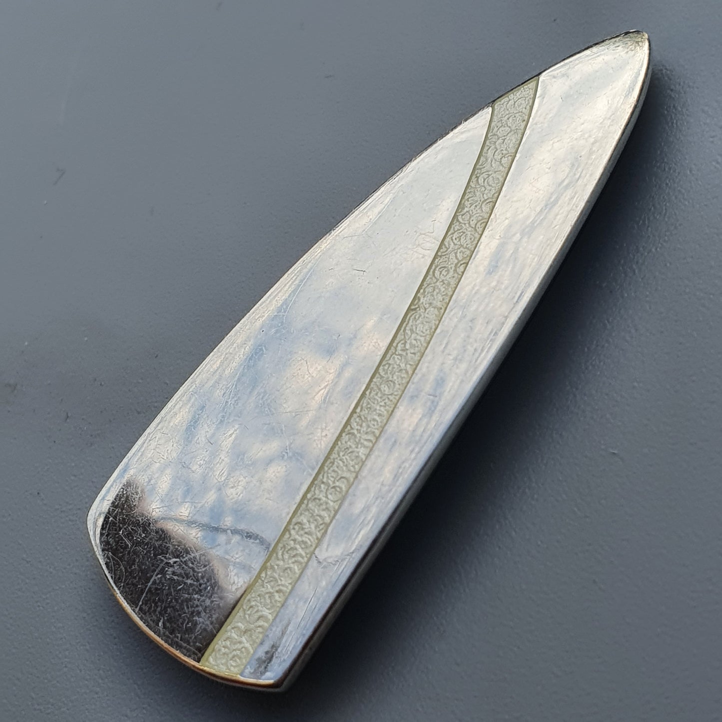 Polished enamel brooch in silver and white with a unique blade shape by Platinoro