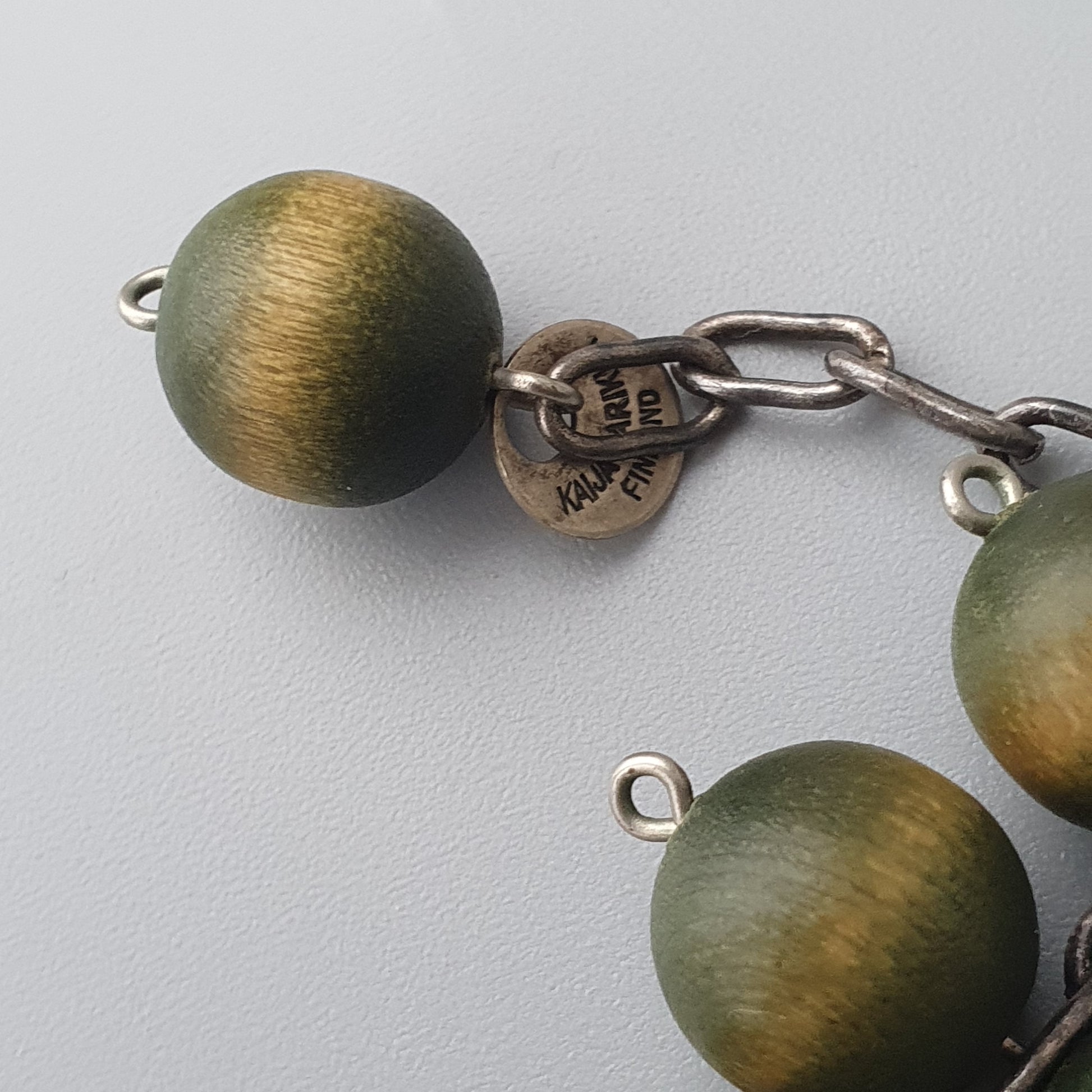 Bracelet or necklace with green and gold spherical beads connected by metal links.