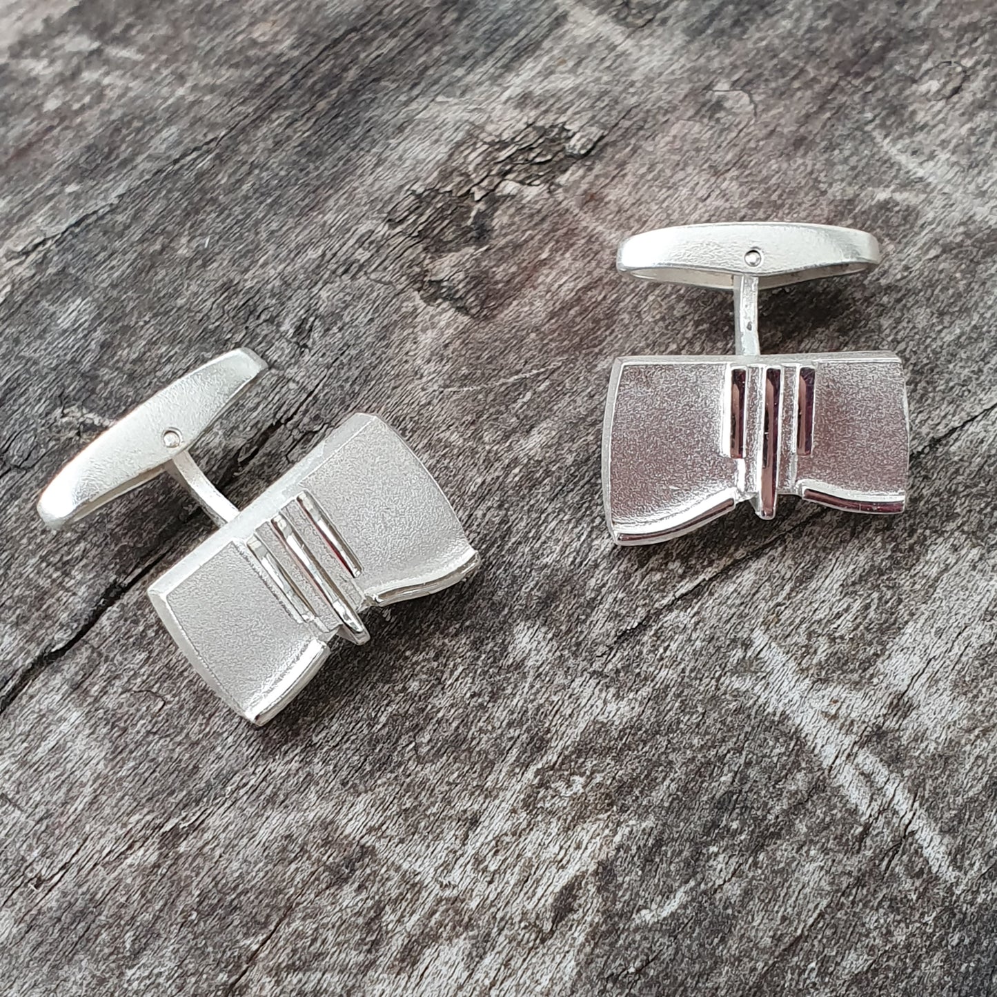 Pair of silver cufflinks with a geometric design.