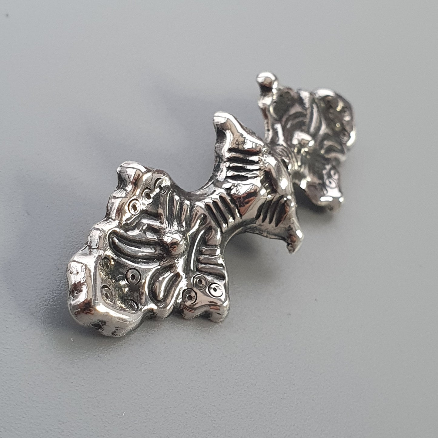 Silver charm or pendant shaped like a whimsical elephant figure.