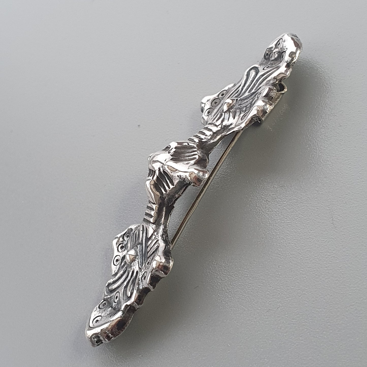 Ornate silver hair clip or barrette with floral and leaf designs.