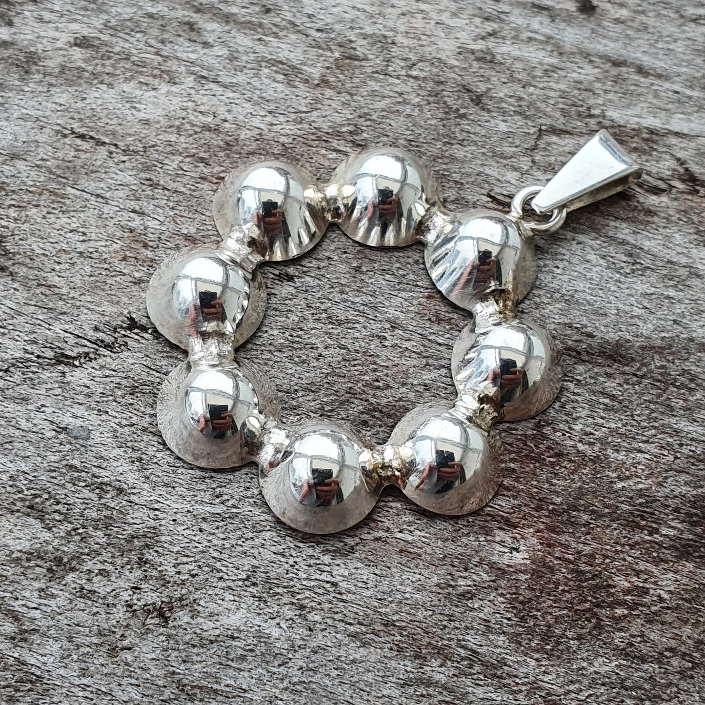 Silver bracelet composed of connected spherical beads.