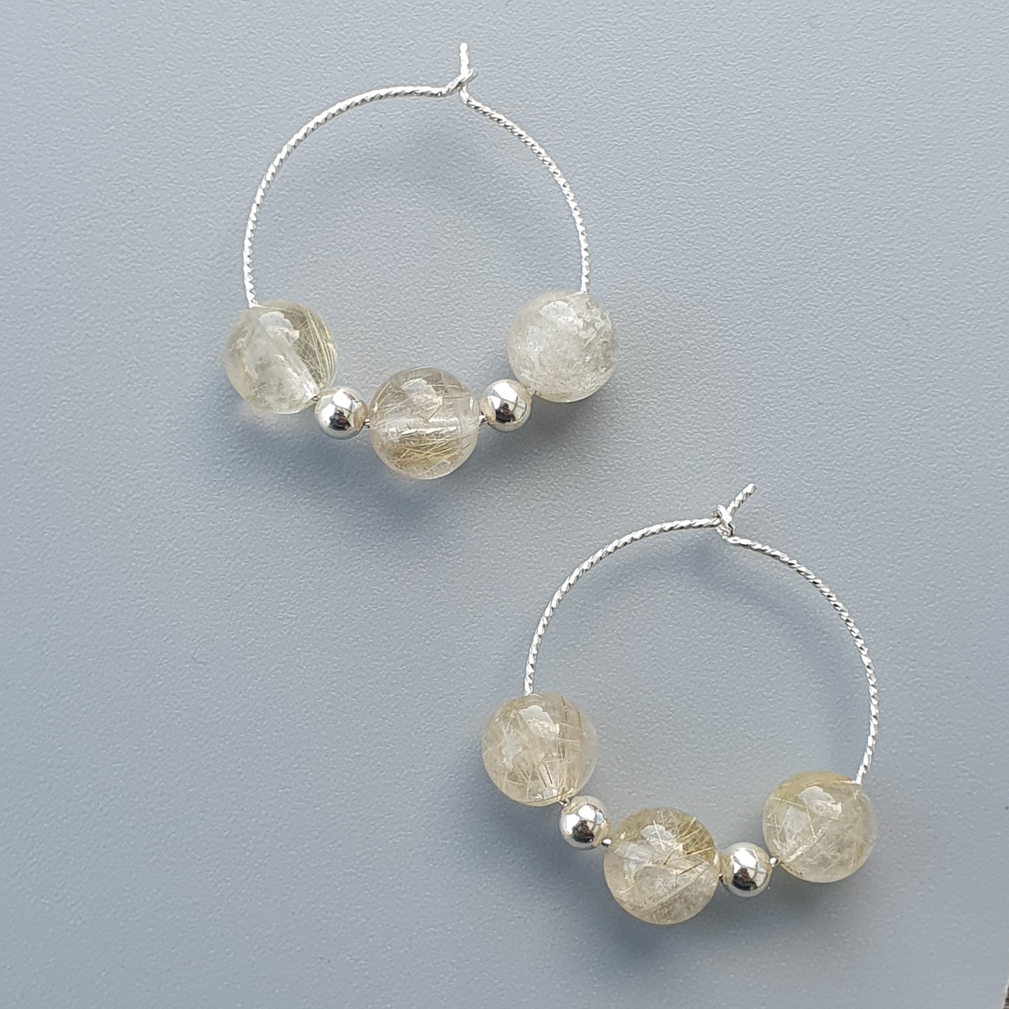 Pair of silver hoop earrings with translucent beads.