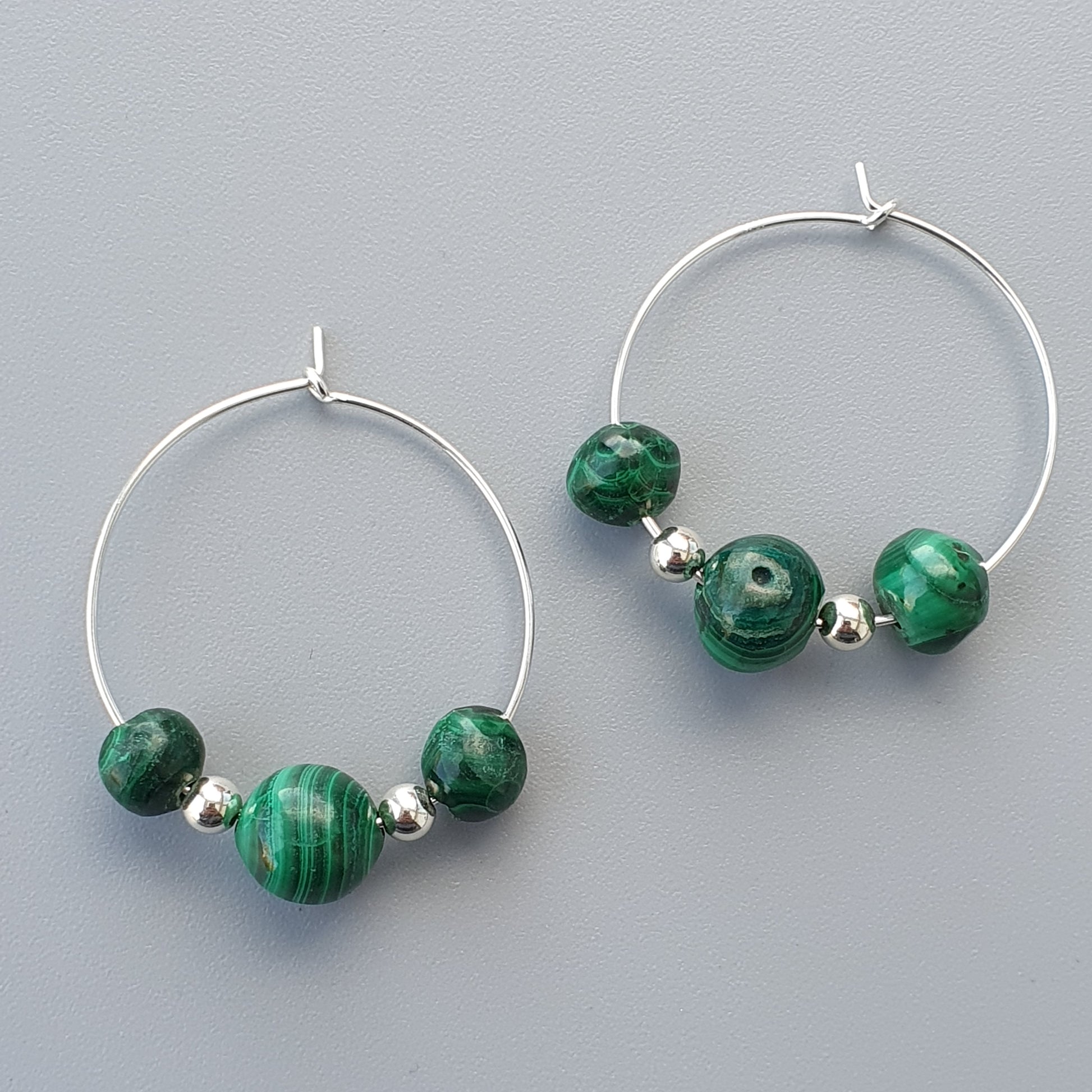 Pair of silver hoop earrings with green malachite beads.