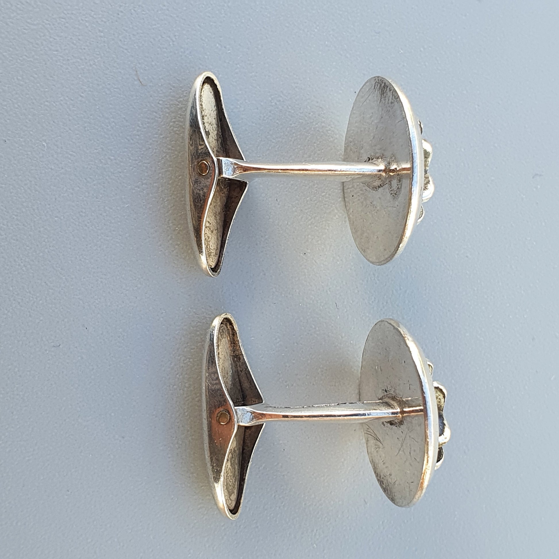 Pair of silver cufflinks with oval-shaped faces.