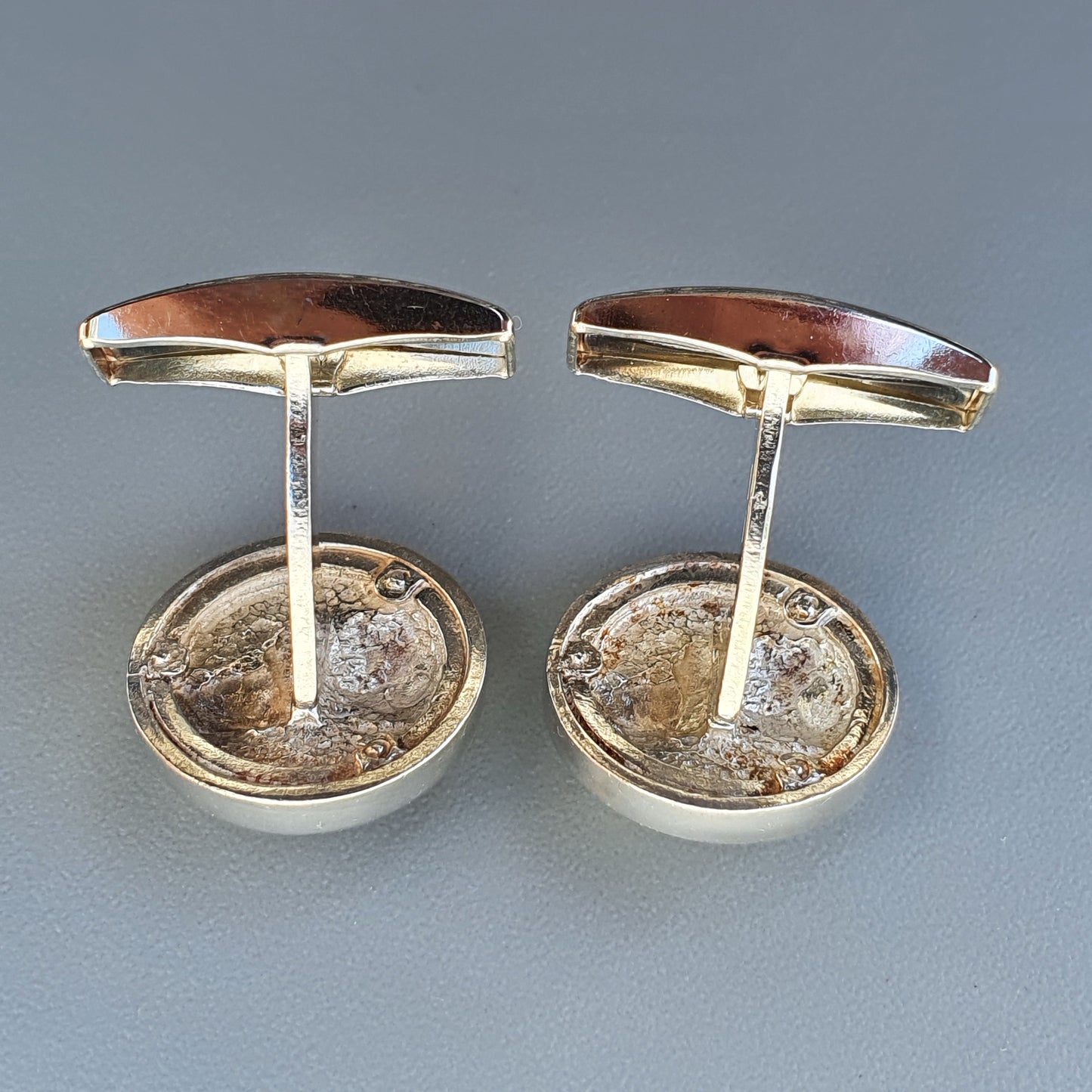 Pair of oval cufflinks with brown gemstone centers and silver-toned metal settings.