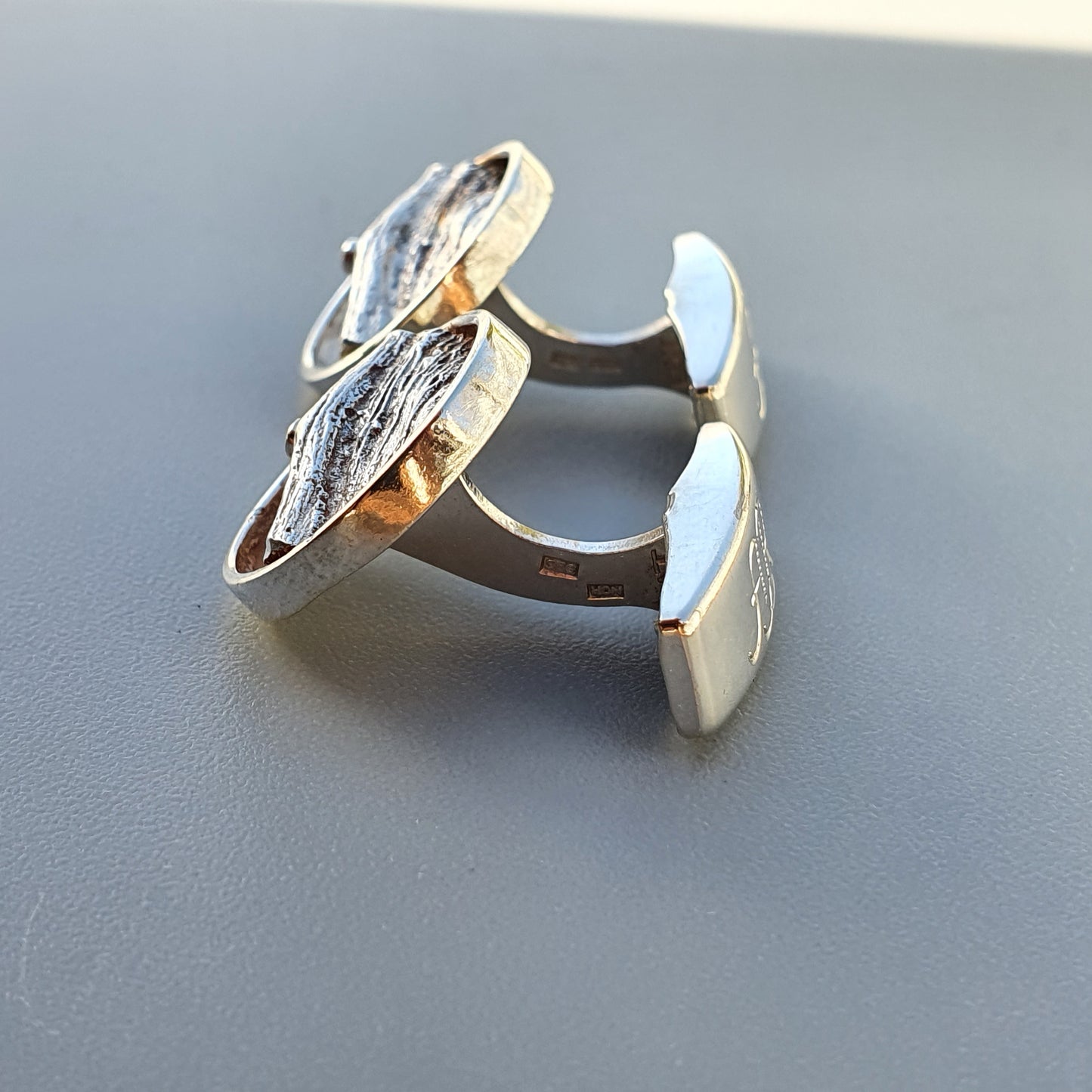 Pair of silver cufflinks with oval-shaped faces.