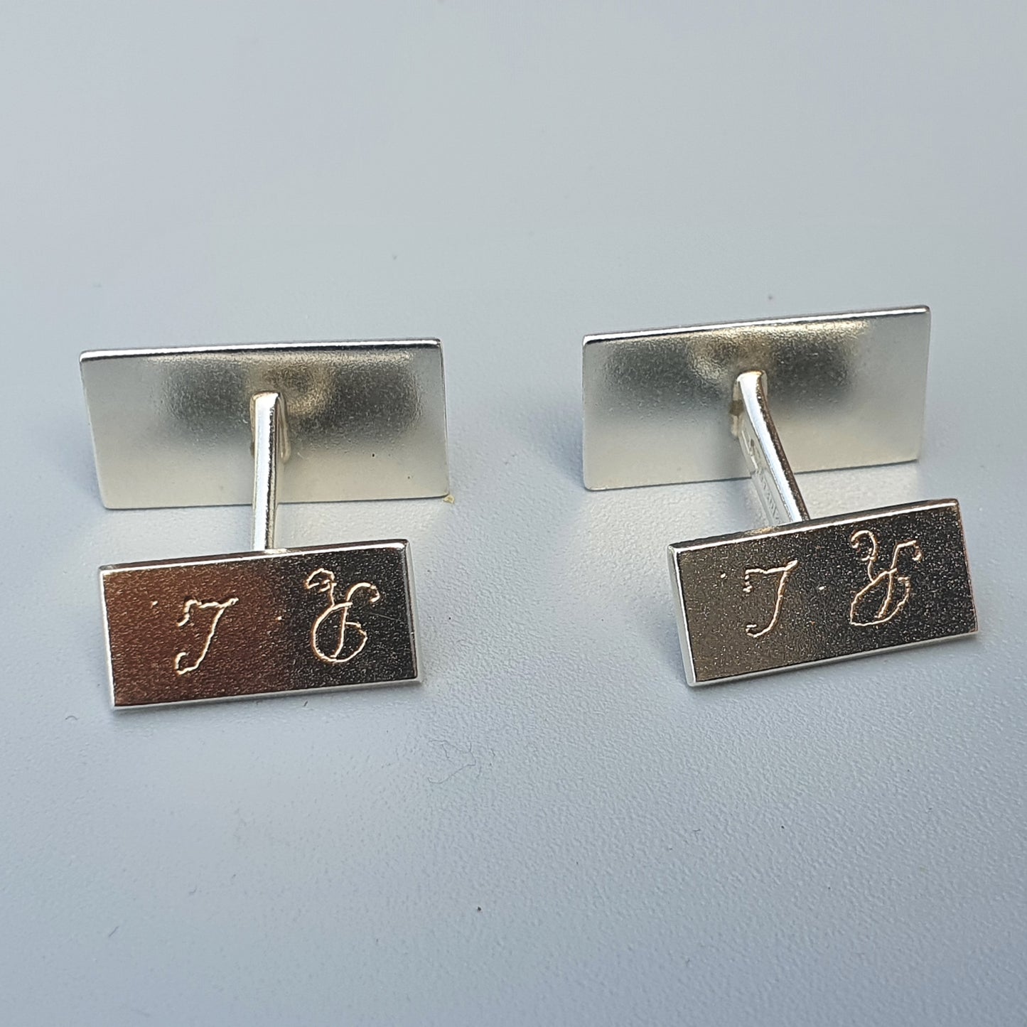 Pair of silver cufflinks with engraved initials ’T C’.