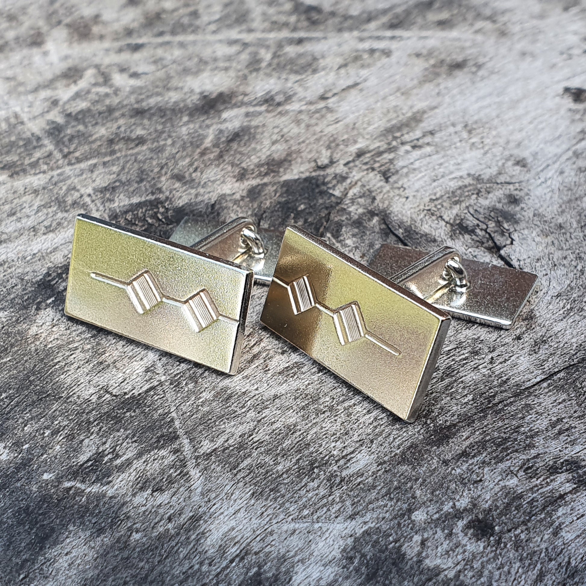 Pair of rectangular gold cufflinks with geometric designs.