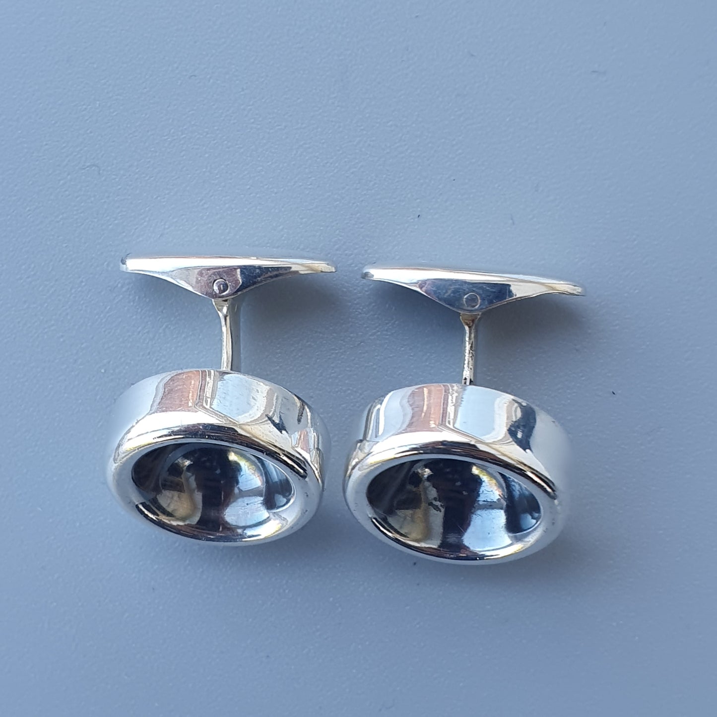 Pair of silver cufflinks with rounded, concave faces.