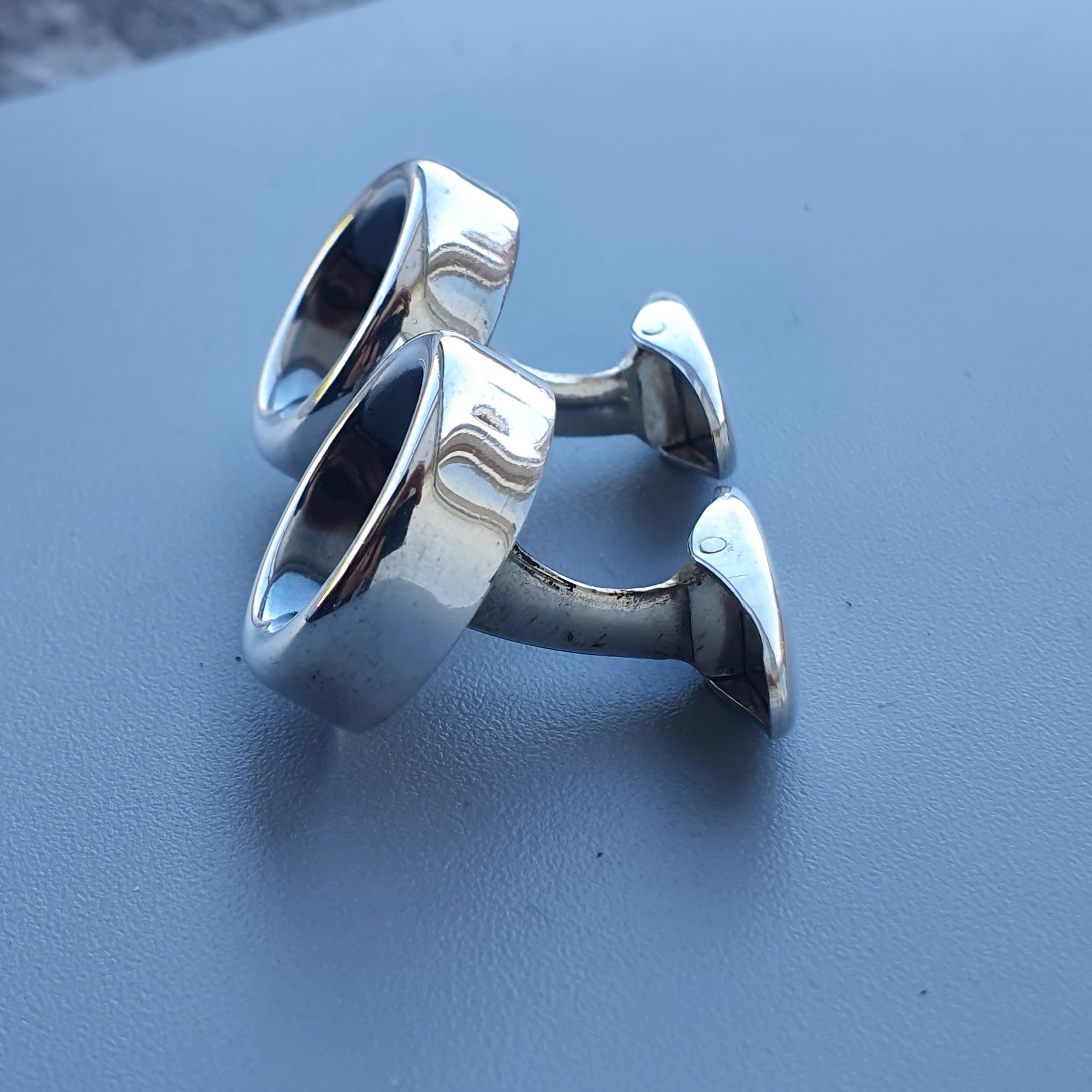 Pair of silver cufflinks with circular faces and curved posts.