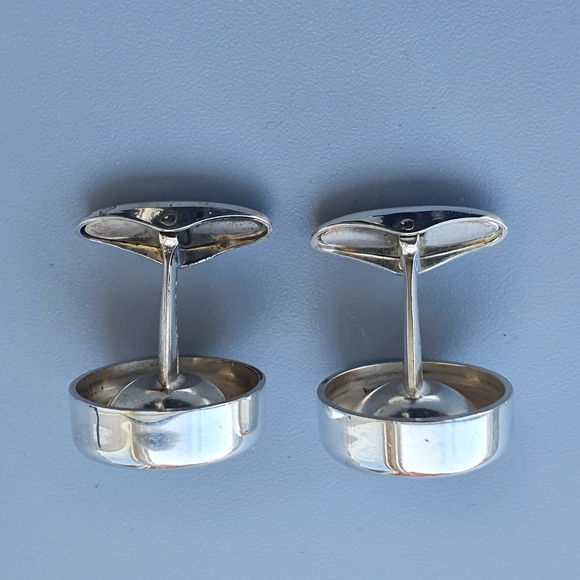 Pair of silver cufflinks with a sleek, modern design.