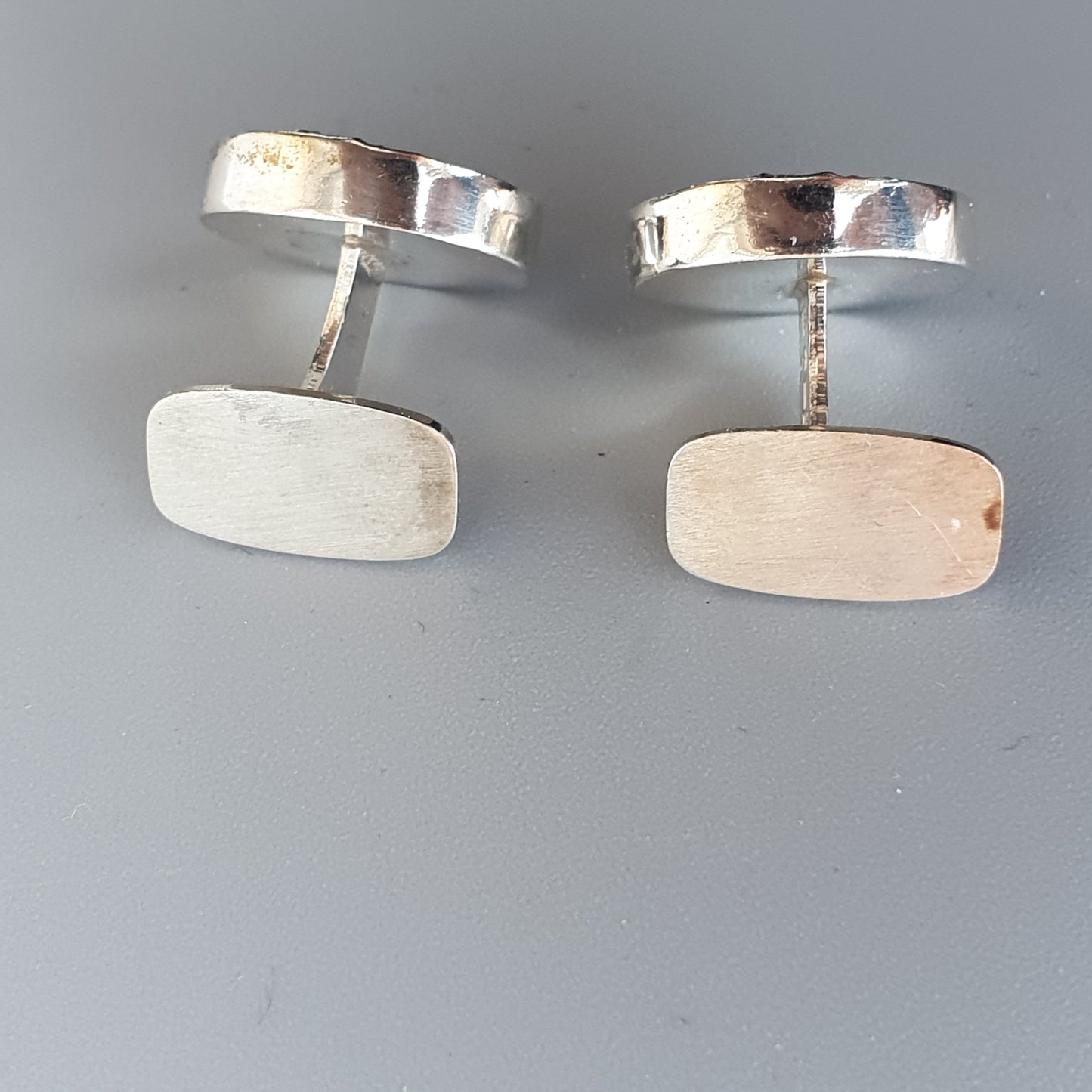 Pair of silver-toned metal cufflinks with rectangular faces.