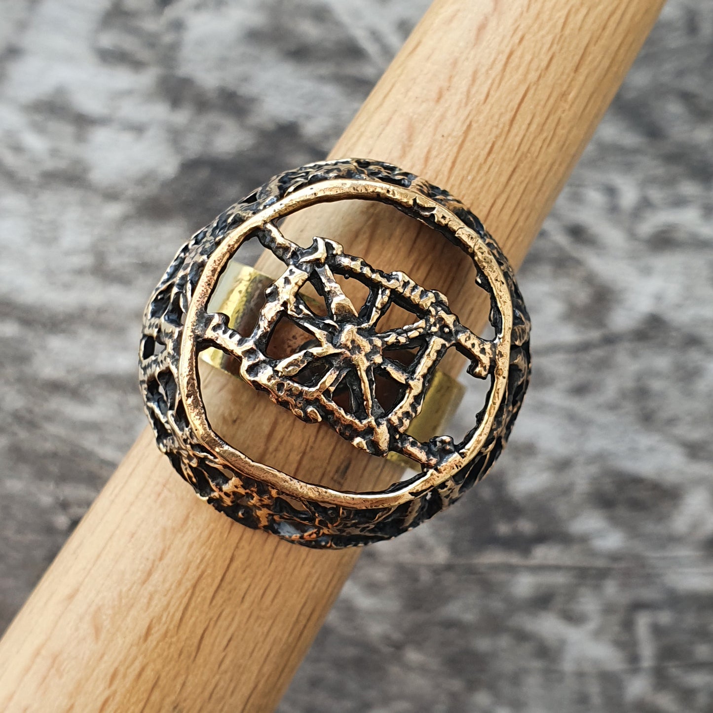 Ornate metal ring with an intricate geometric design in the center.