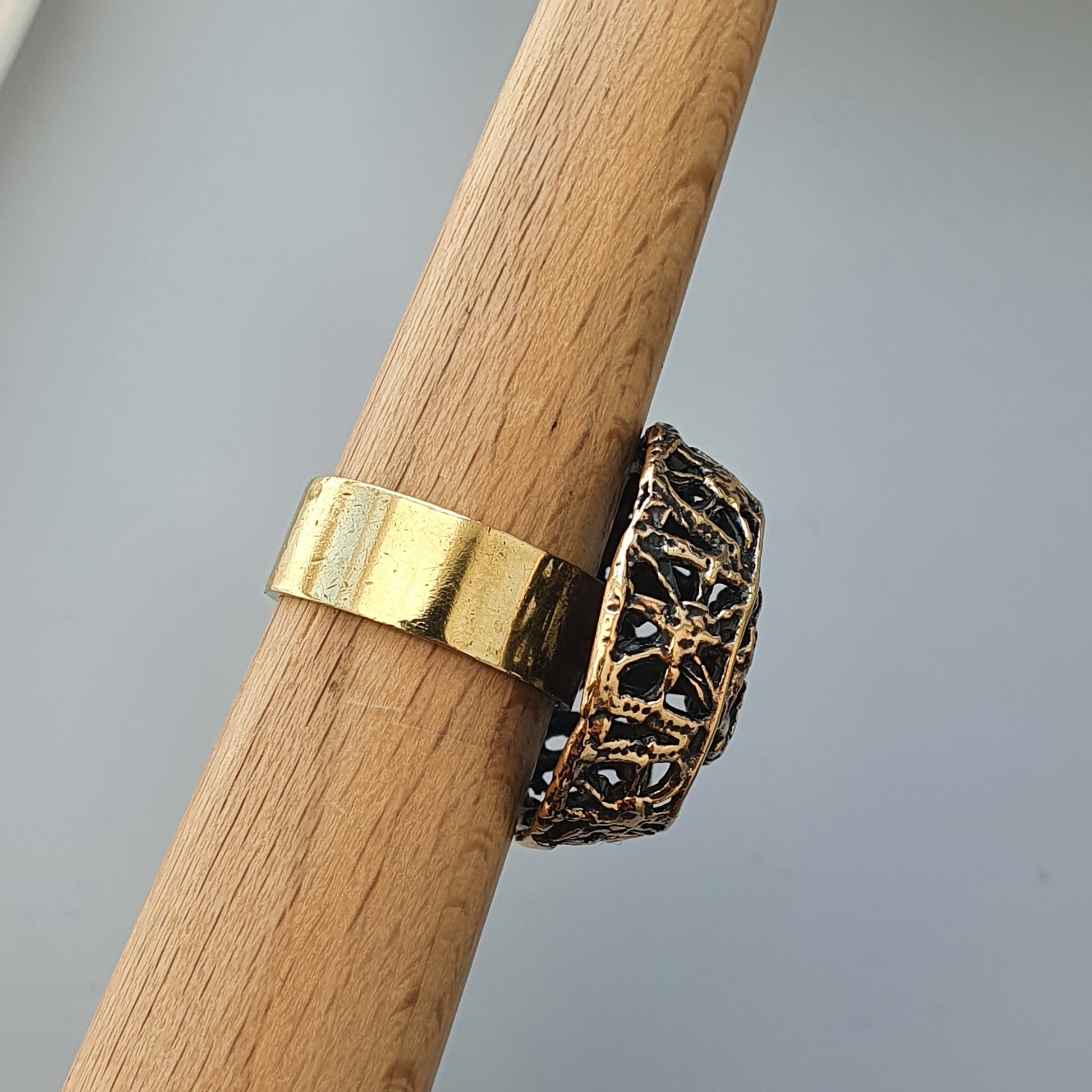 Ornate gold and black filigree ring with an intricate design.