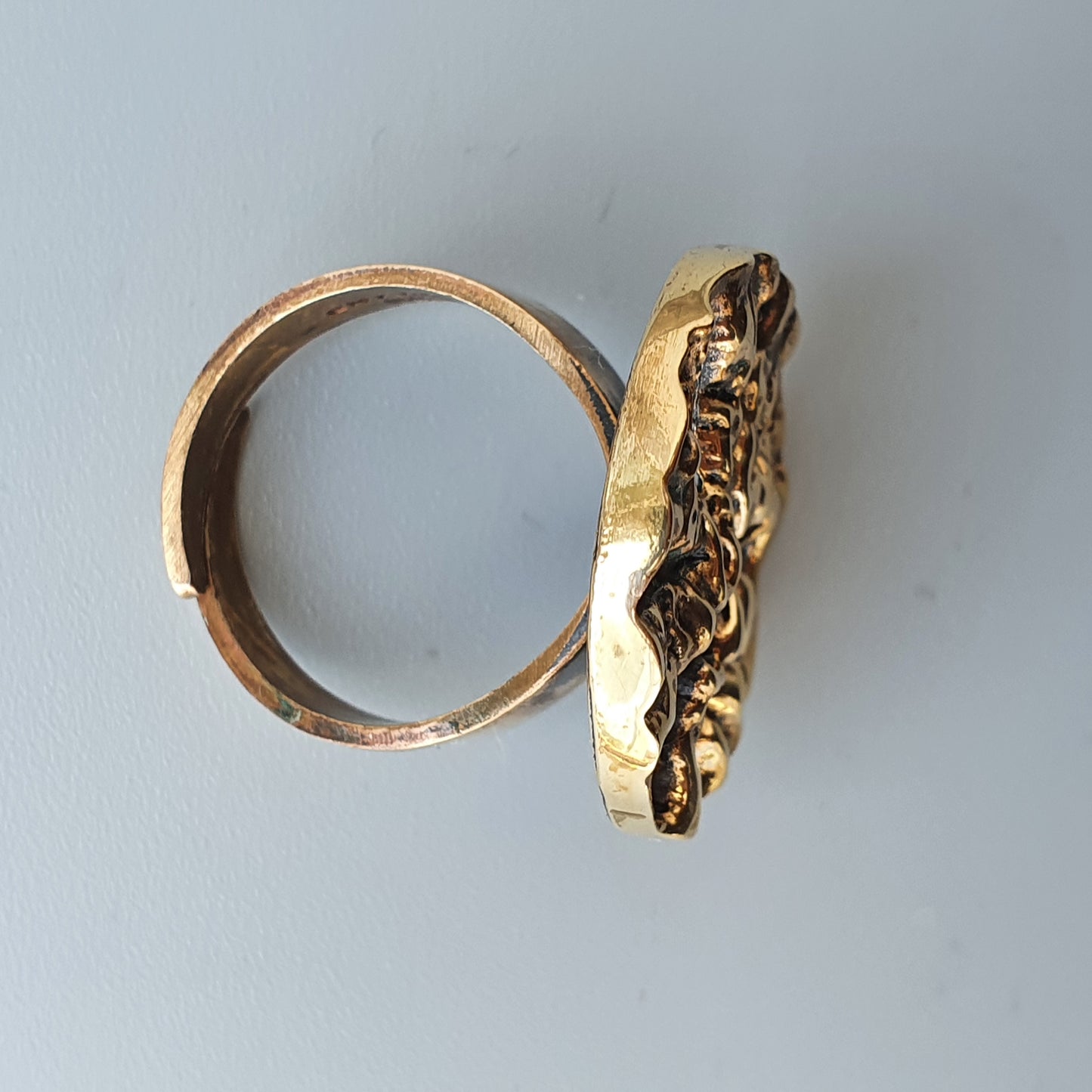 Gold ring with an elongated, textured top design.