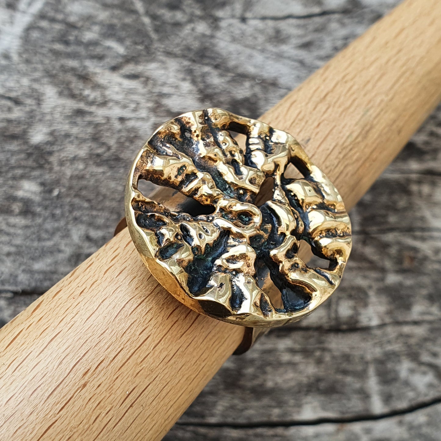 Gold ring with a textured circular face resembling a brain or coral pattern.