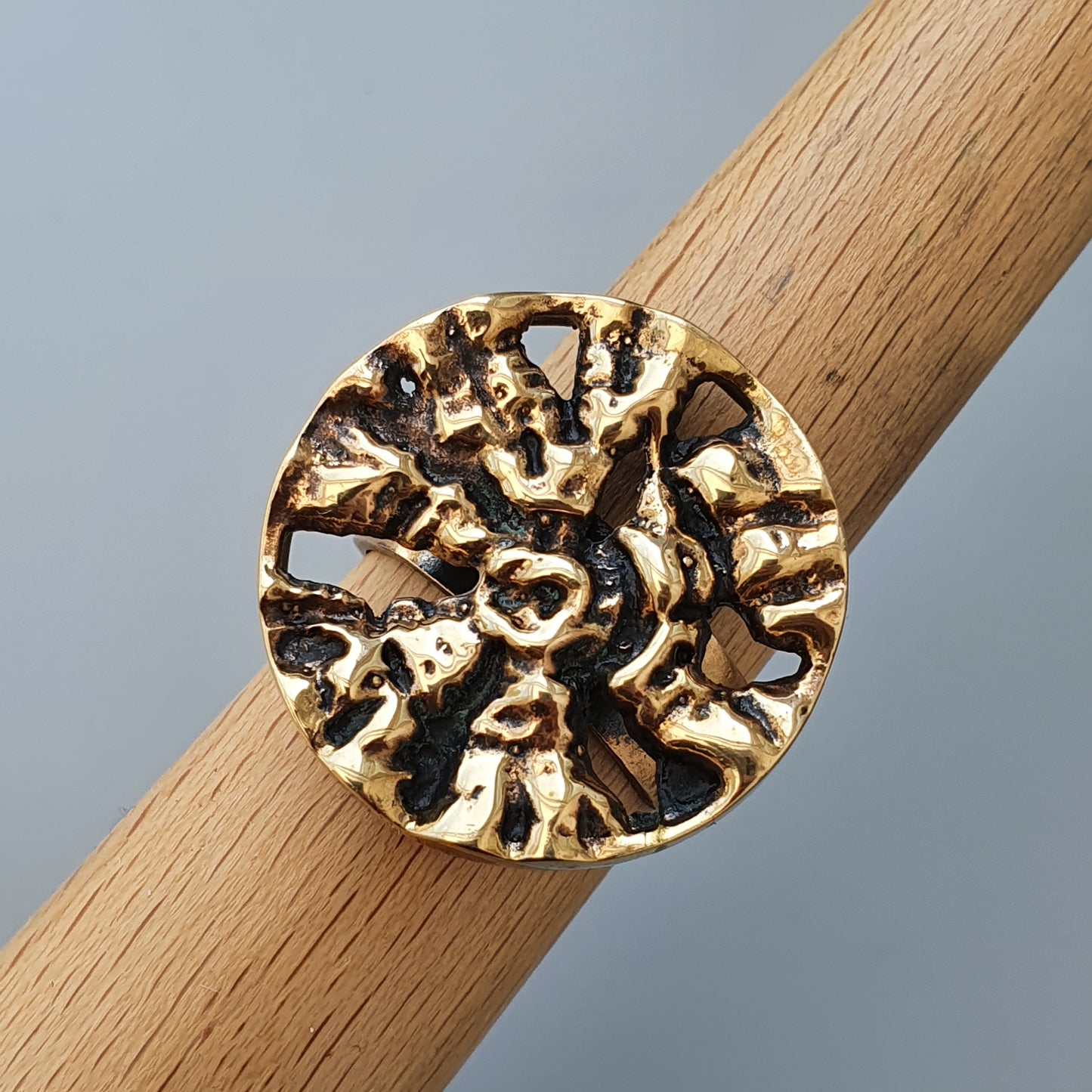 Ornate gold ring with an intricate circular design resembling coral or abstract patterns.