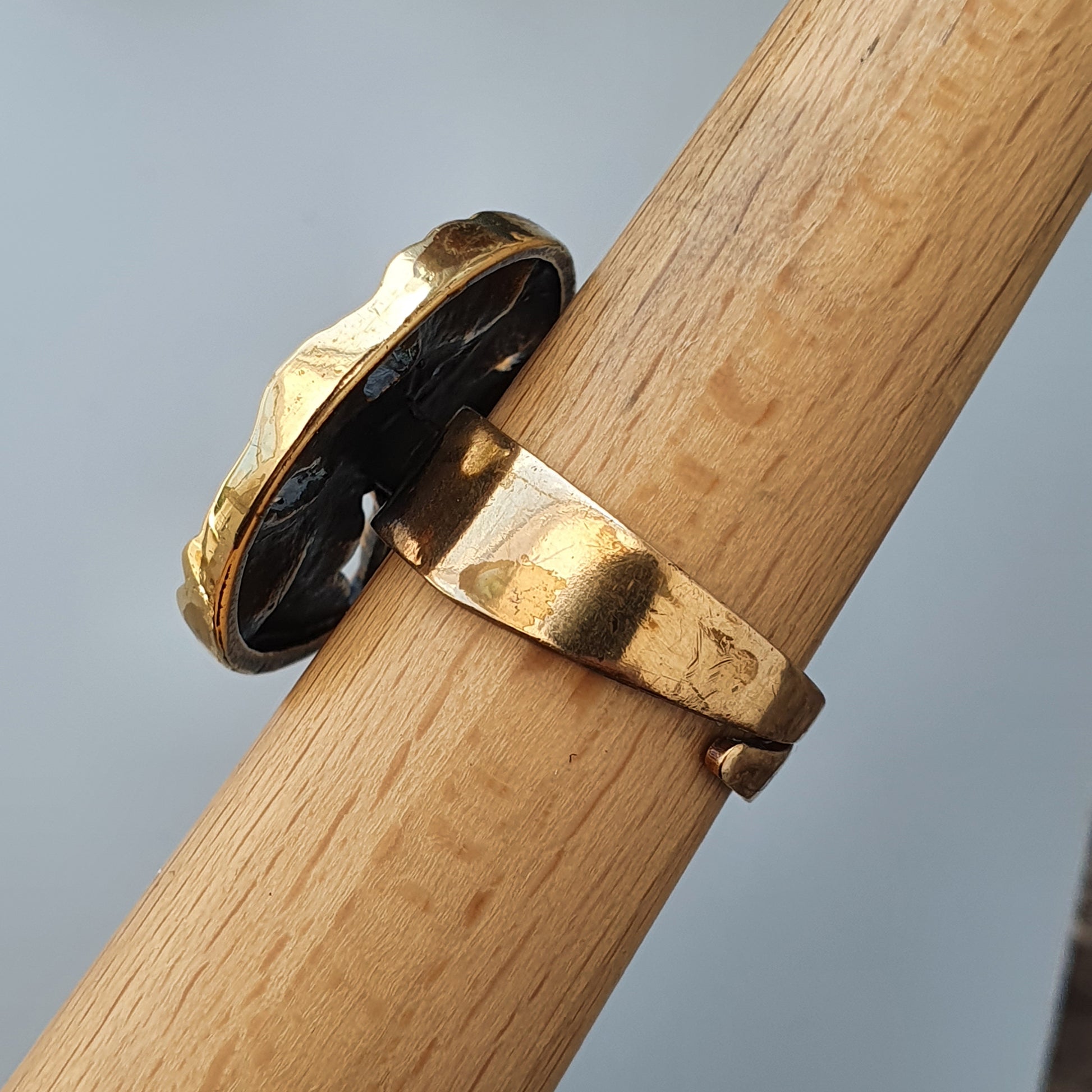 Gold ring with a black oval stone or inlay.