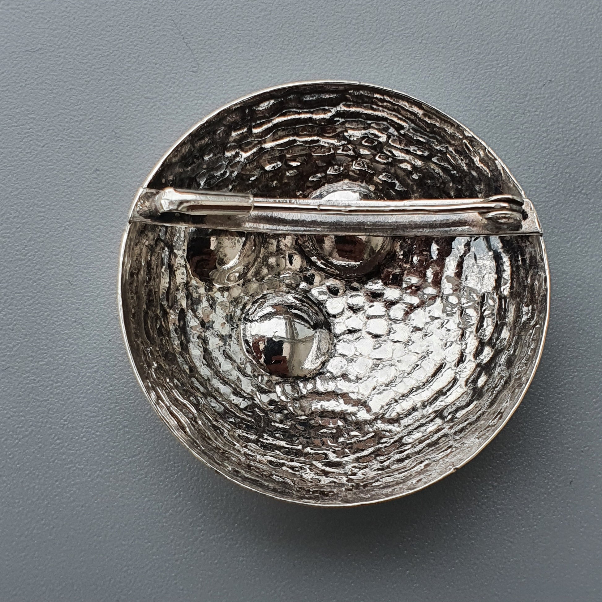 Hammered silver bowl or dish with a textured, dimpled surface and a raised rim.