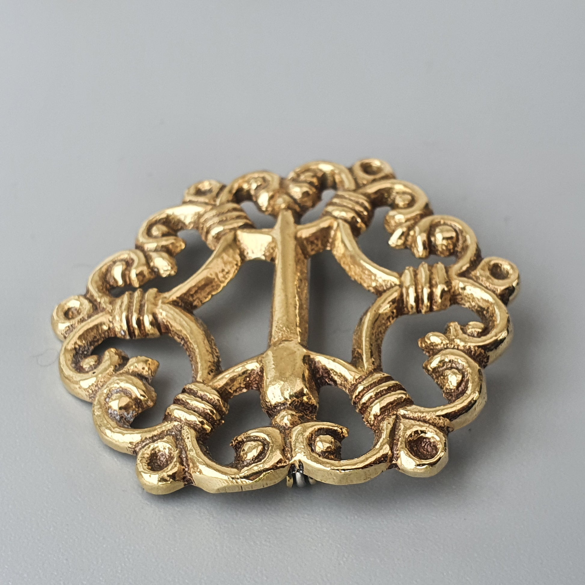 Ornate gold-colored metal buckle with intricate scrollwork design.