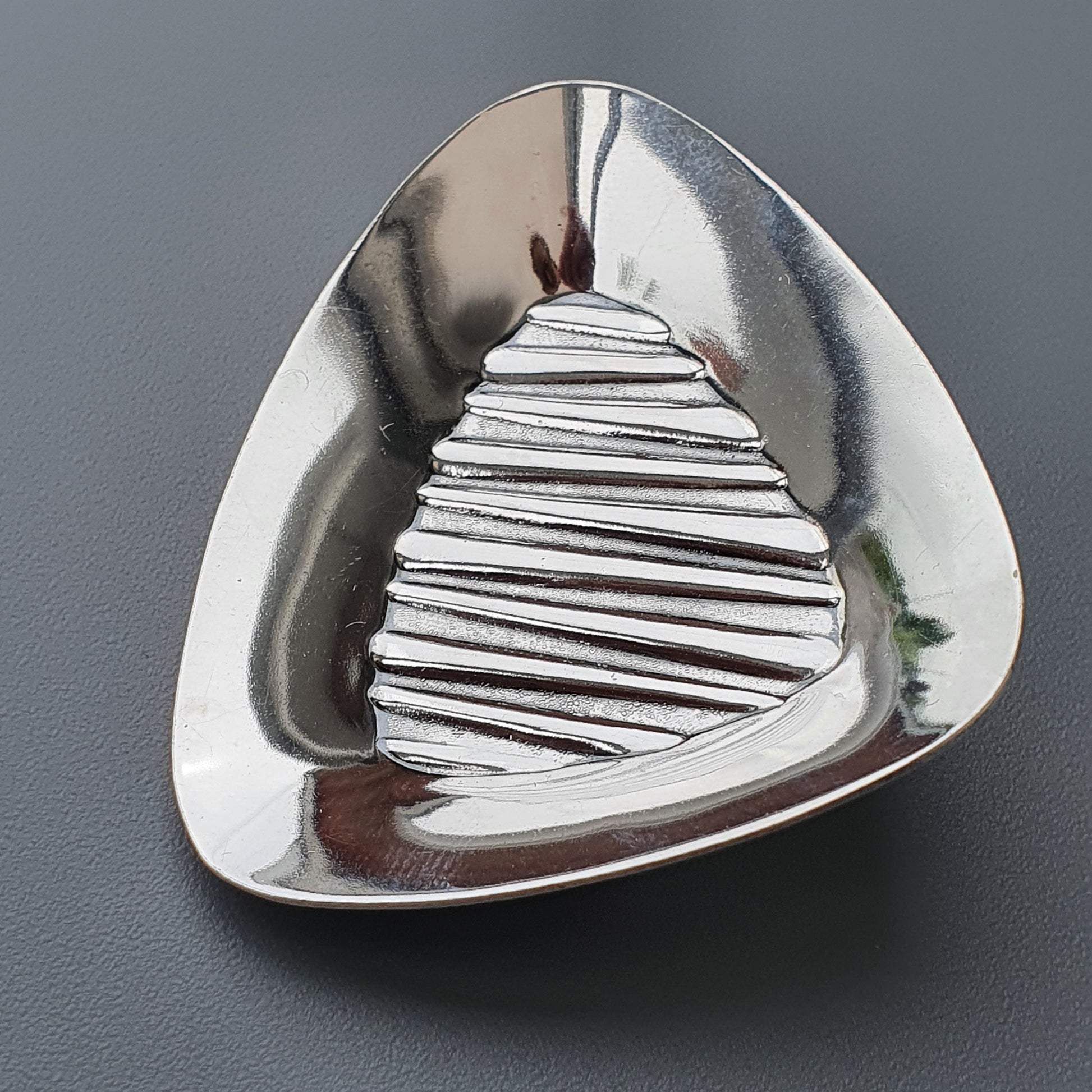 Triangular metallic dish with a ridged, pyramid-shaped center.