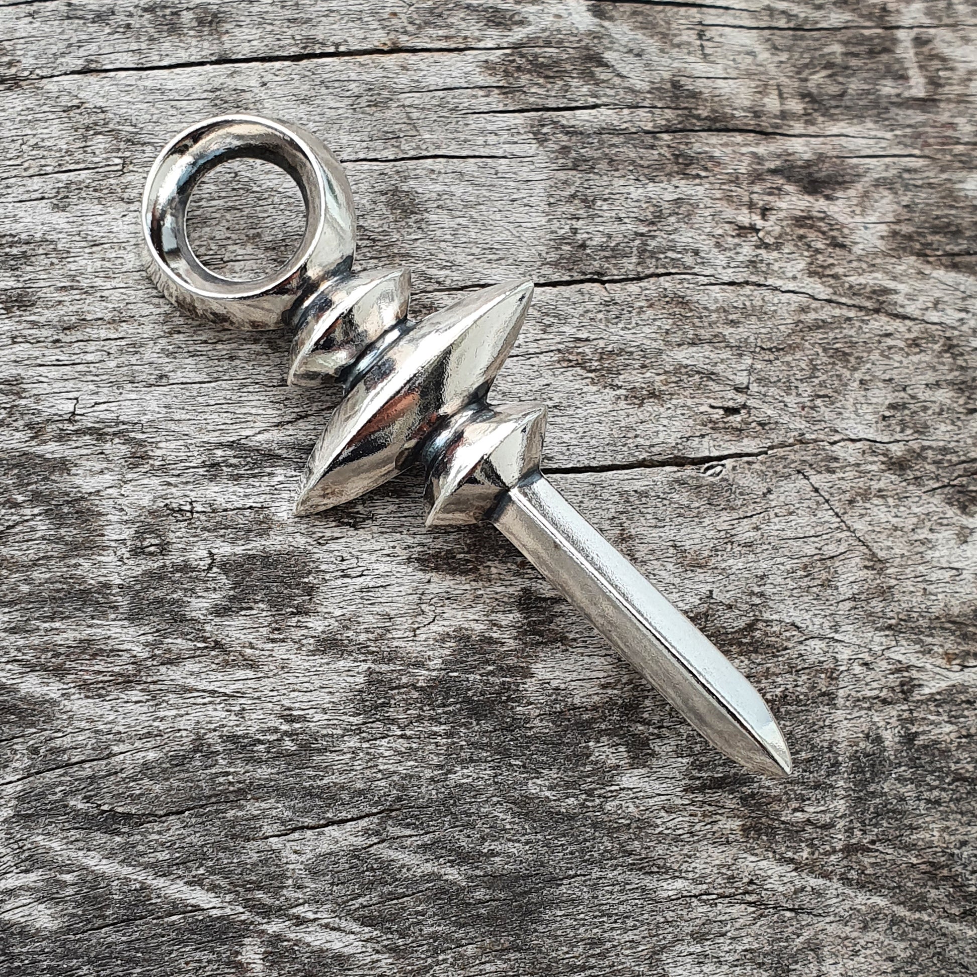 Silver brooch in a shape of a stylised middle ages style sword