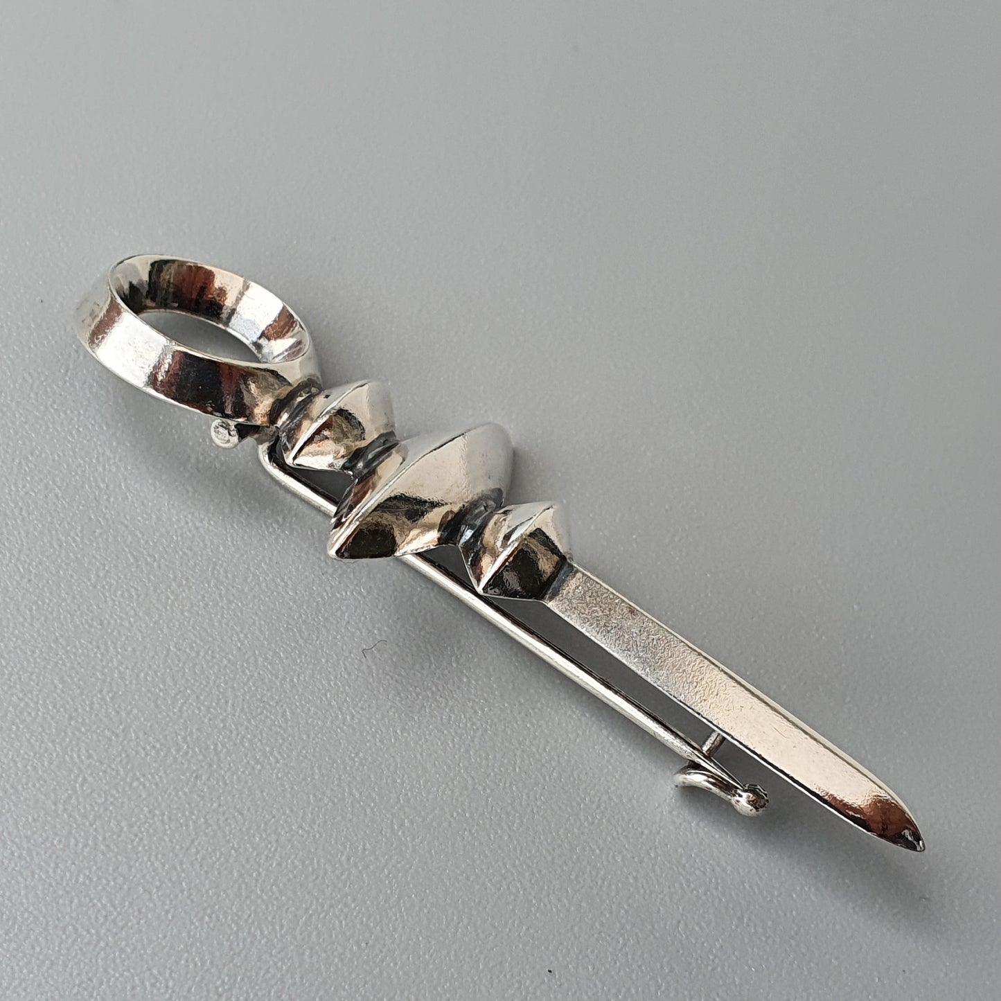 Metallic hair clip or barrette with a twisted, sculptural design.