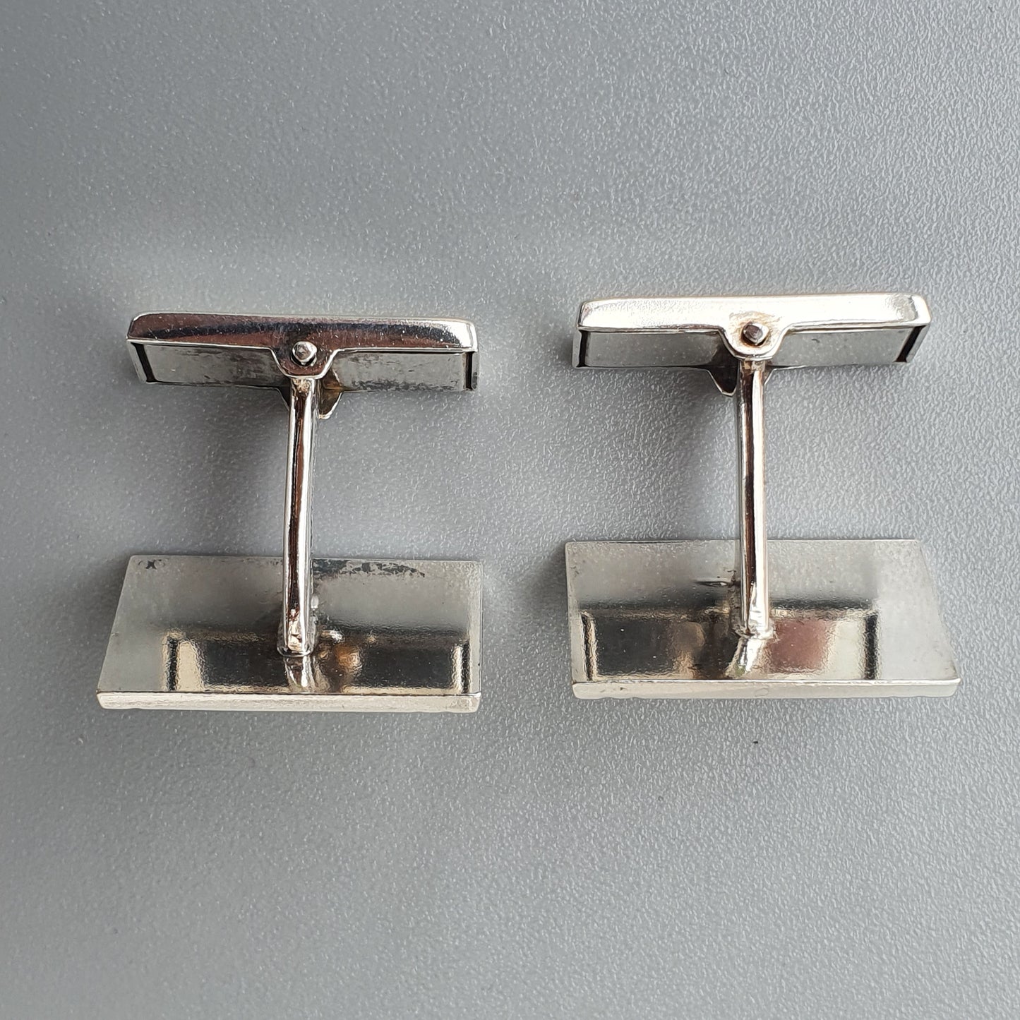 Pair of silver-colored rectangular cufflinks.