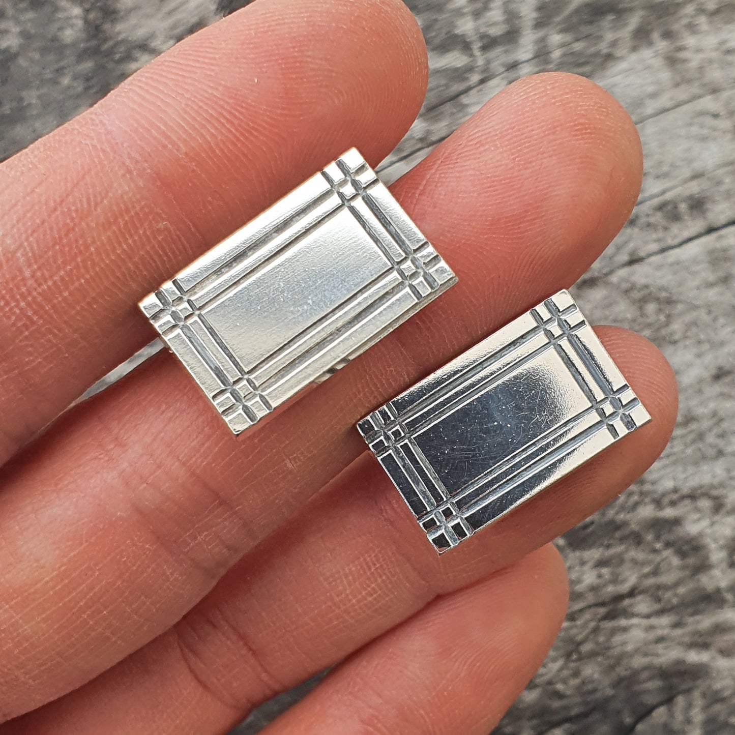 Pair of rectangular silver cufflinks with a gridded design.