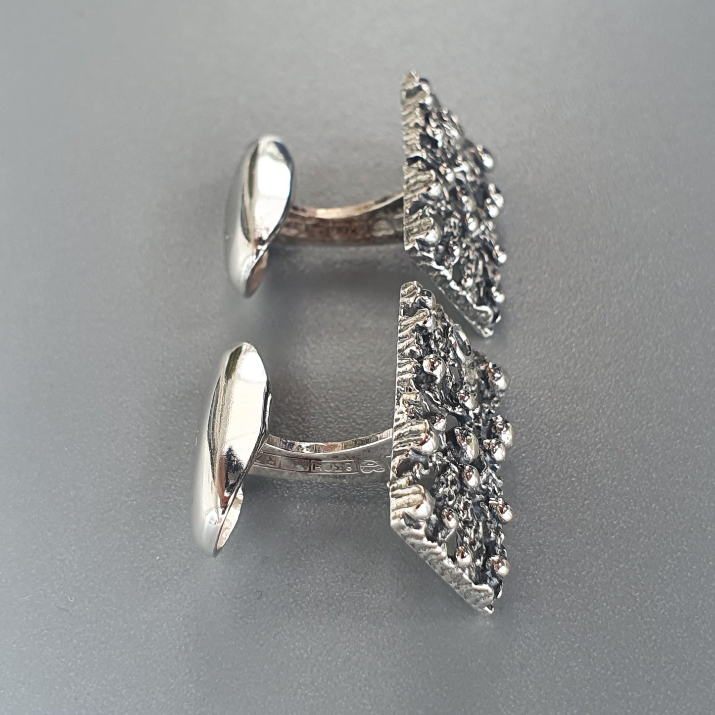 Pair of silver cufflinks with textured, crystalline-like surfaces.