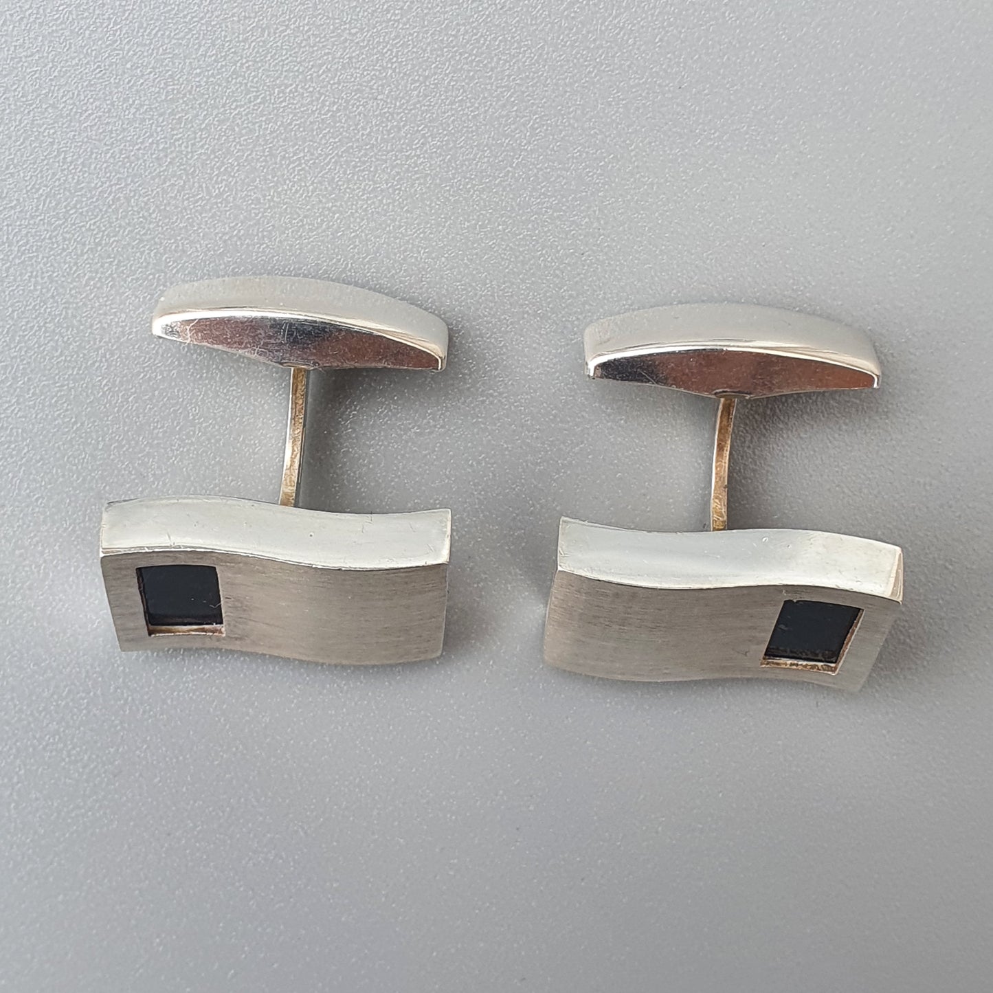 Pair of modernist silver cufflinks with black inlay accents.