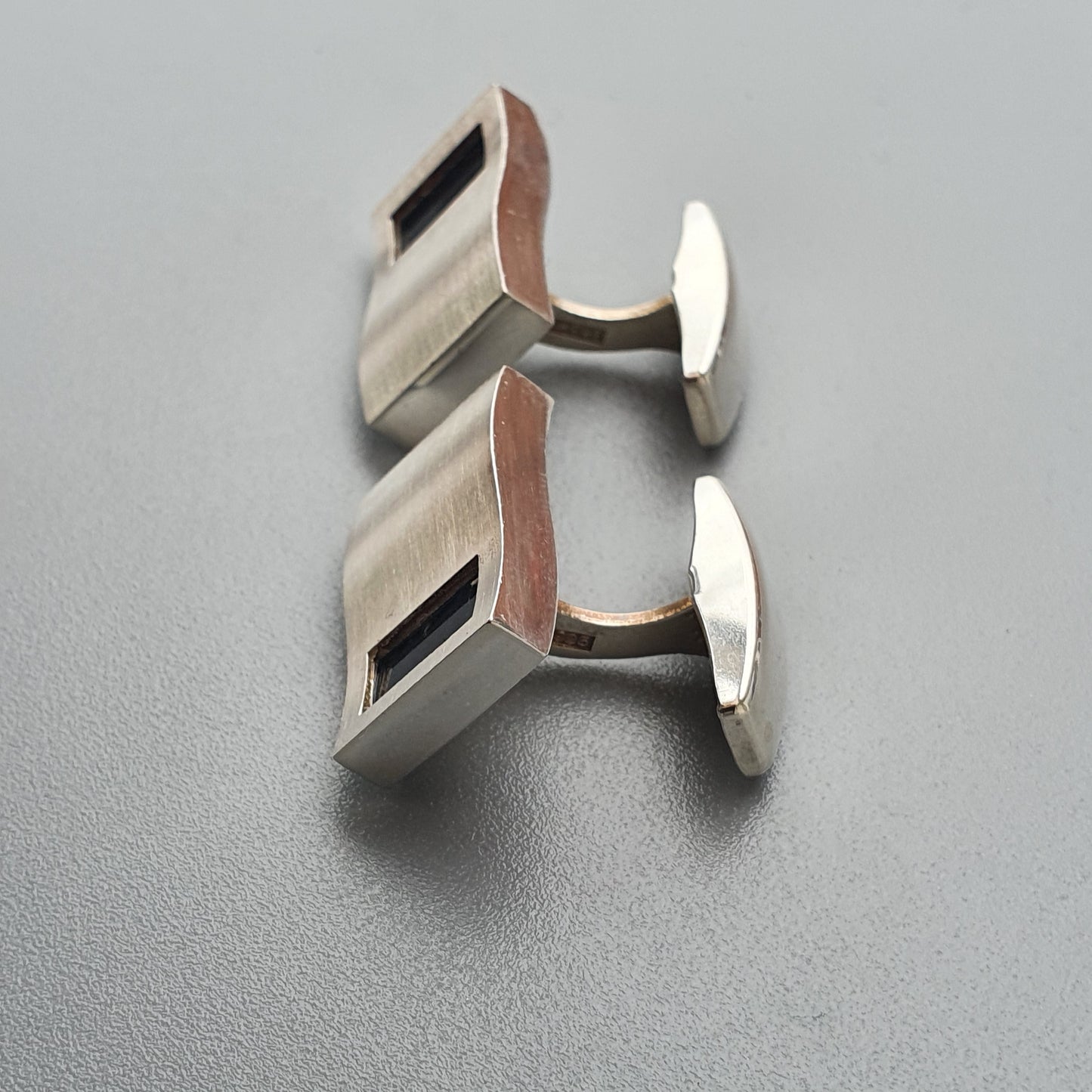 Pair of silver and copper-toned rectangular cufflinks.