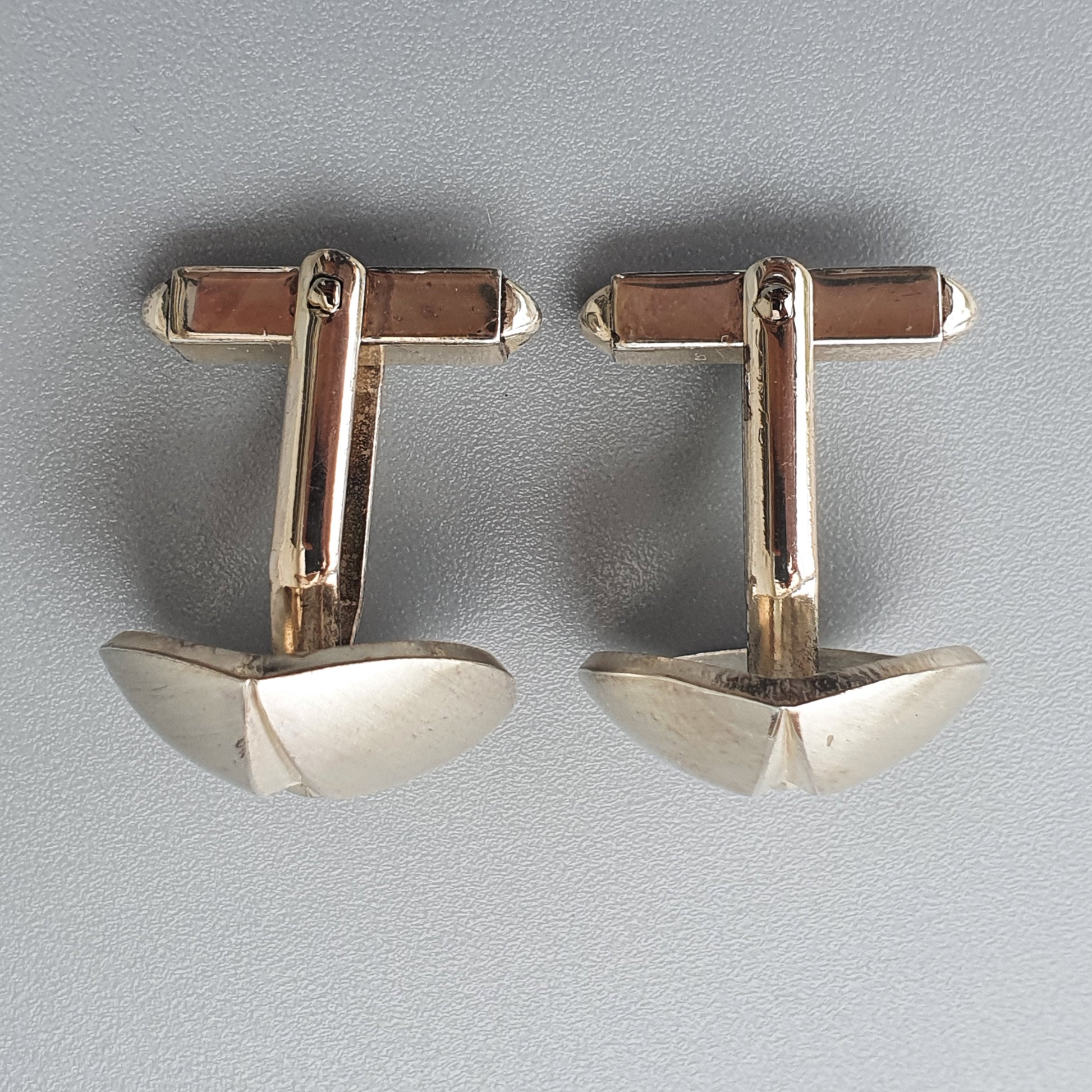 Pair of silver-toned metal cufflinks with triangular ends.