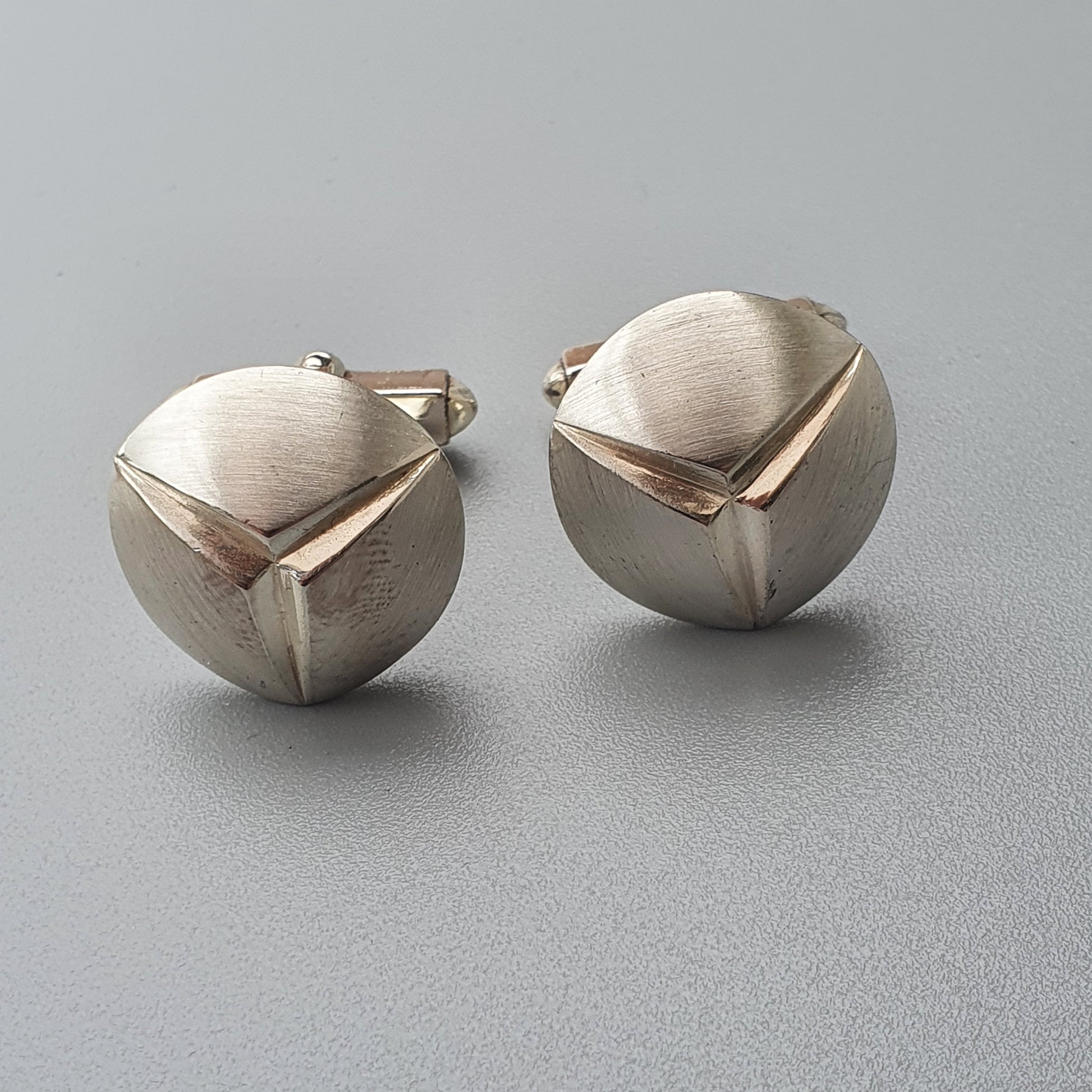 Pair of spherical silver earrings with geometric gold accents.