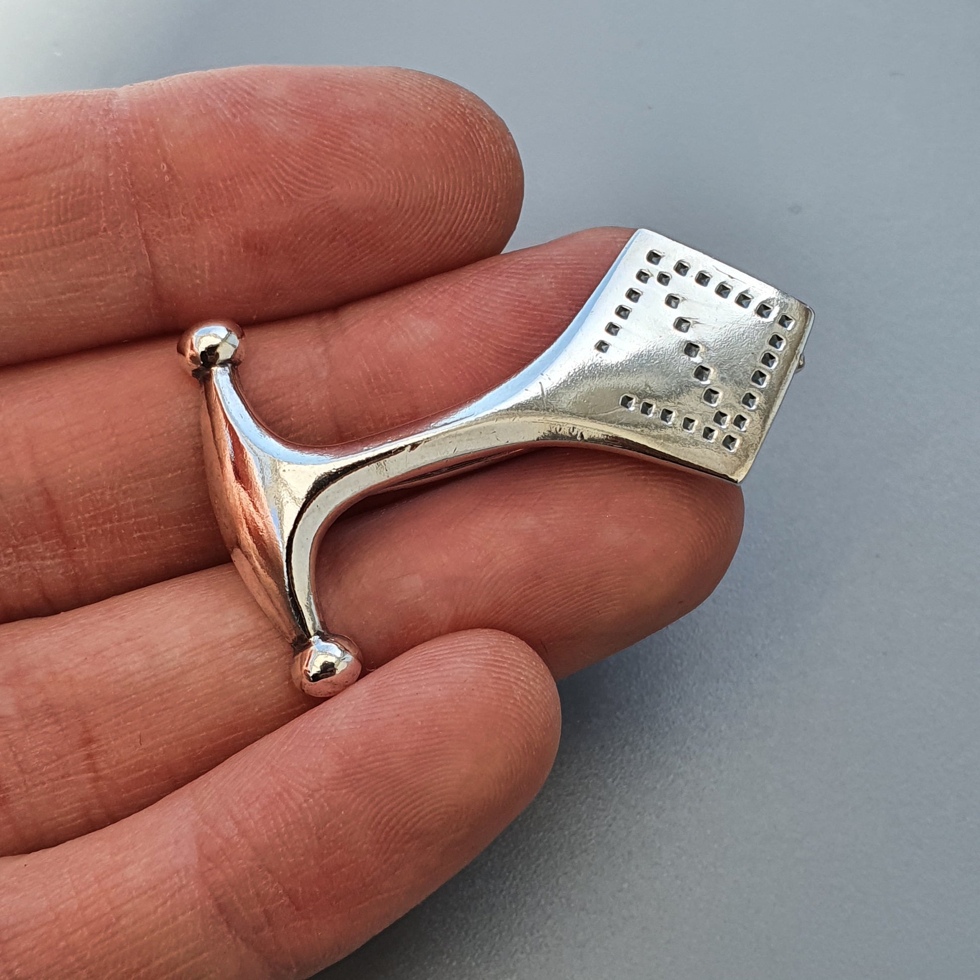 Silver fidget ring with a spinning bar and textured surface.